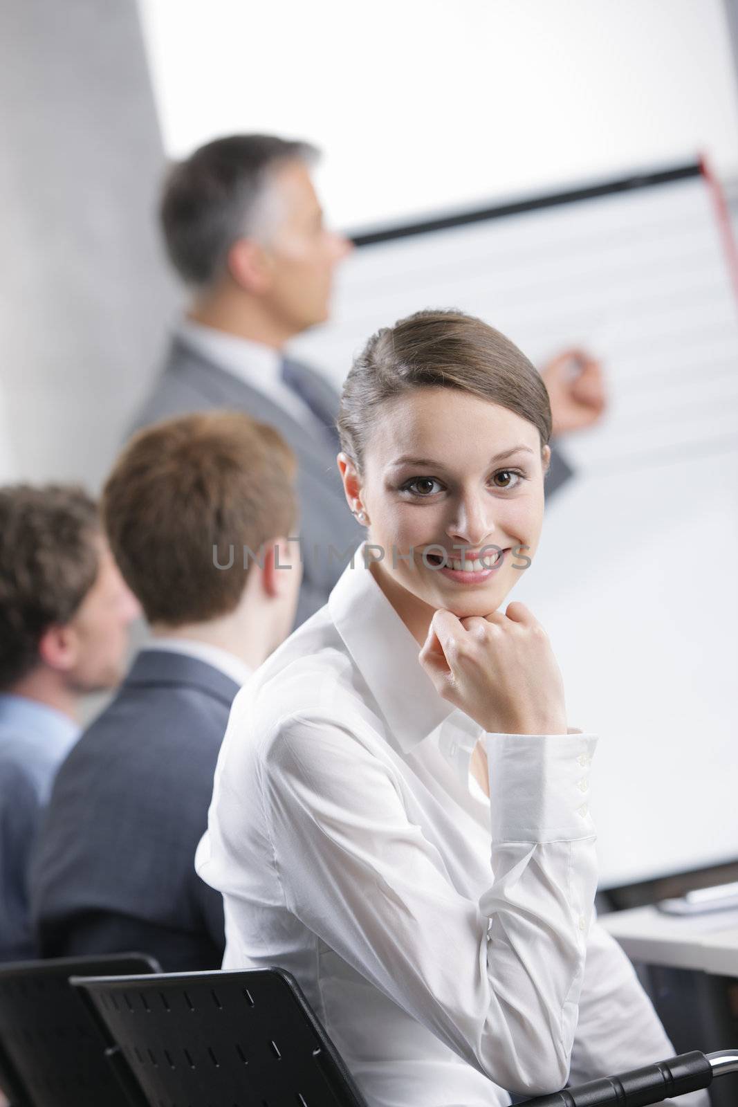 Smiling woman sitting at a business meeting with colleagues