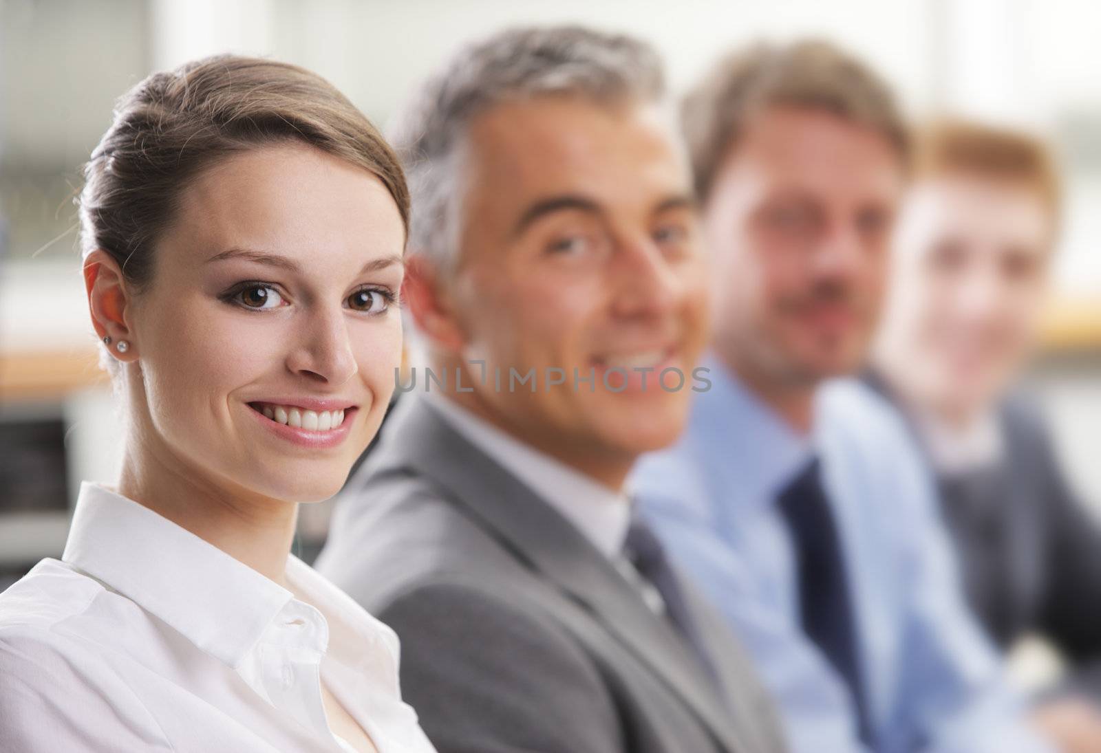 Beautiful young business woman smiling in a meeting with her colleagues 