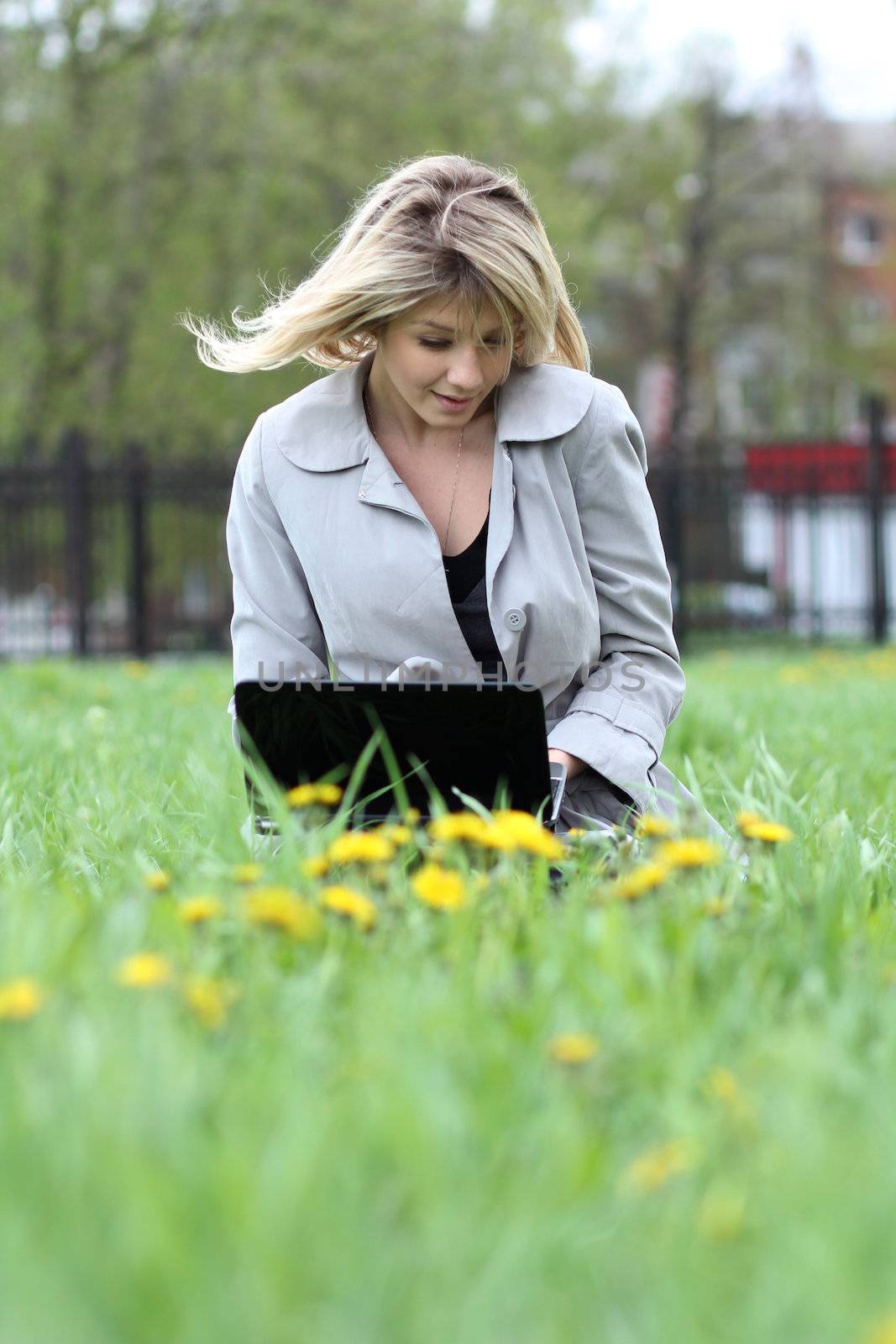 young blond having fun with laptop outdoors