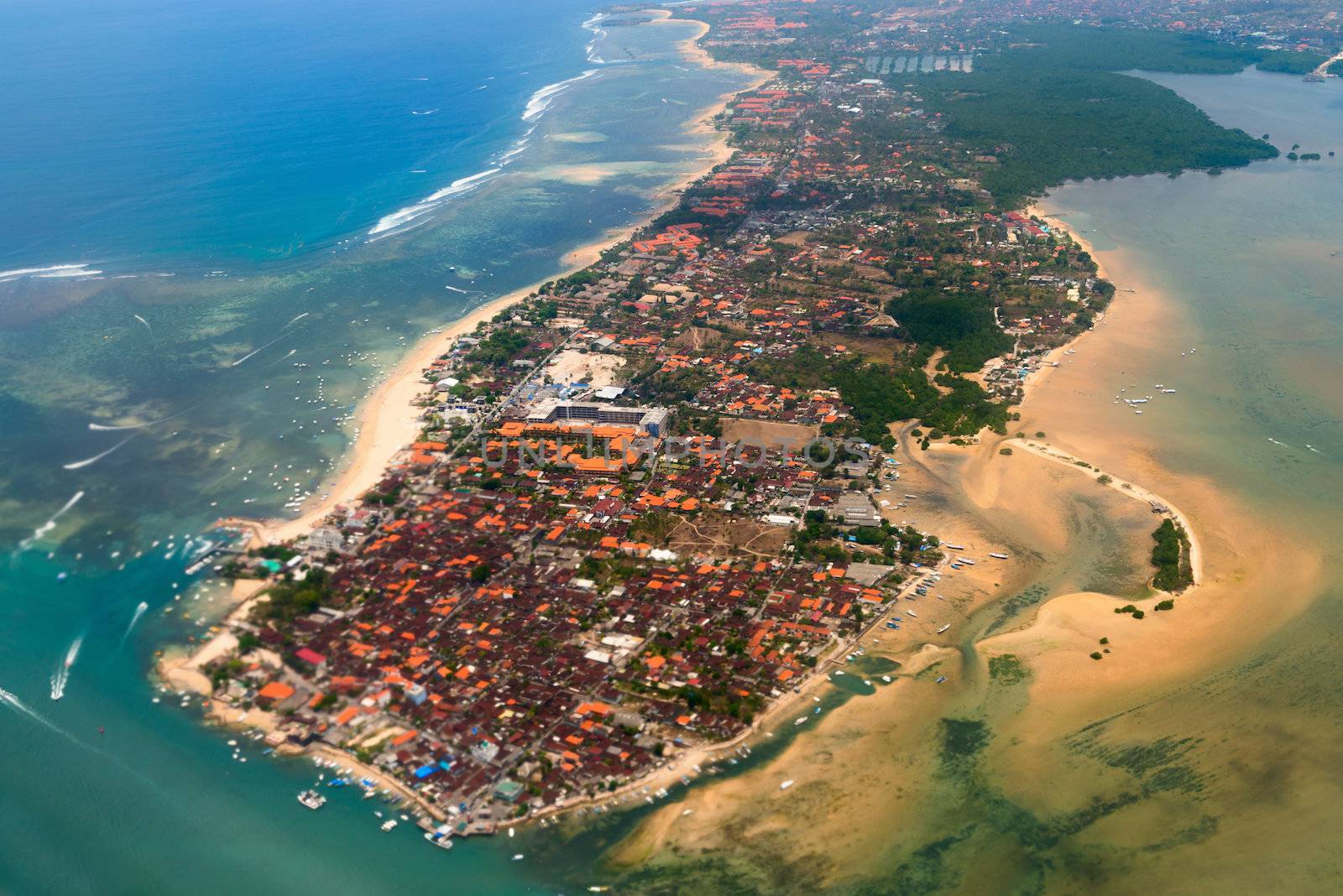 Aerial view of Nusa Dua beach on Bali showing roofs of many hotels and restaurants