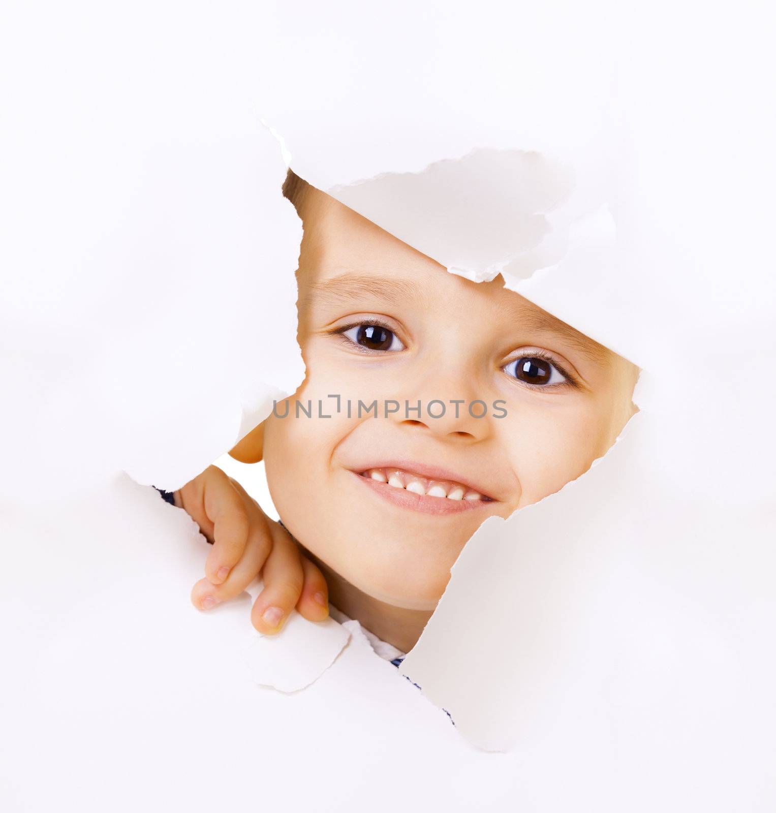 Smiling kid looking out of a hole of white paper
