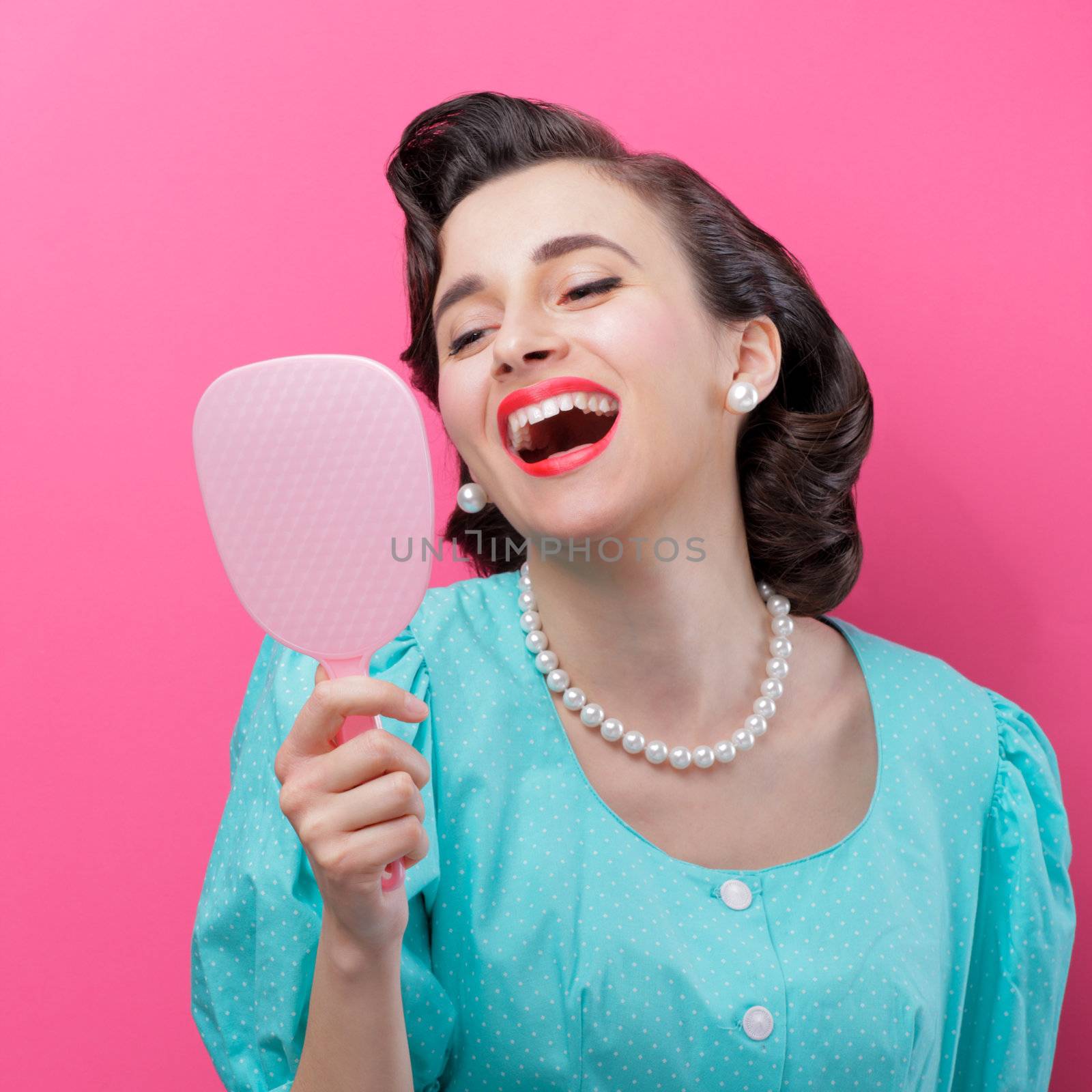 Happy woman looking at her face in the mirror.