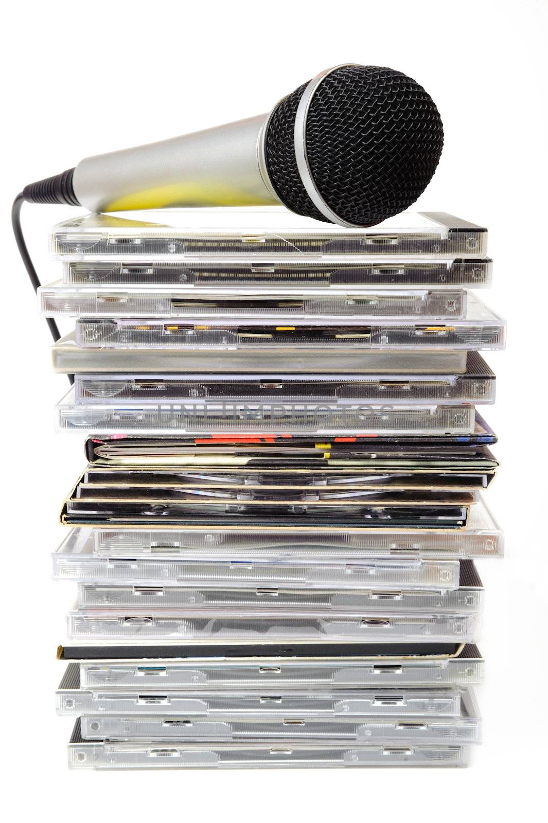 Microphone and karaoke compact disc collection on white background