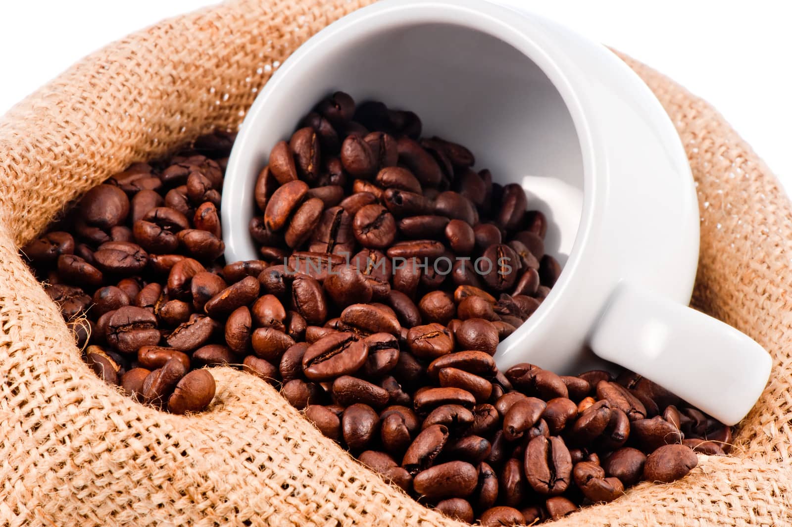 White cup in a bag of coffee beans