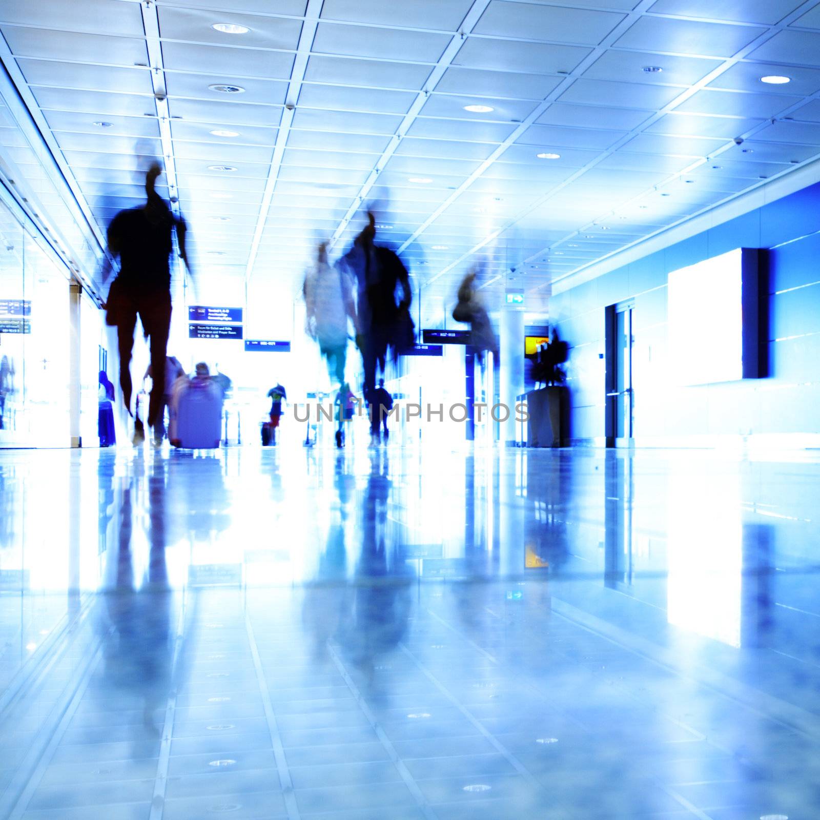 Passengers walking in contemporary hallway of airport