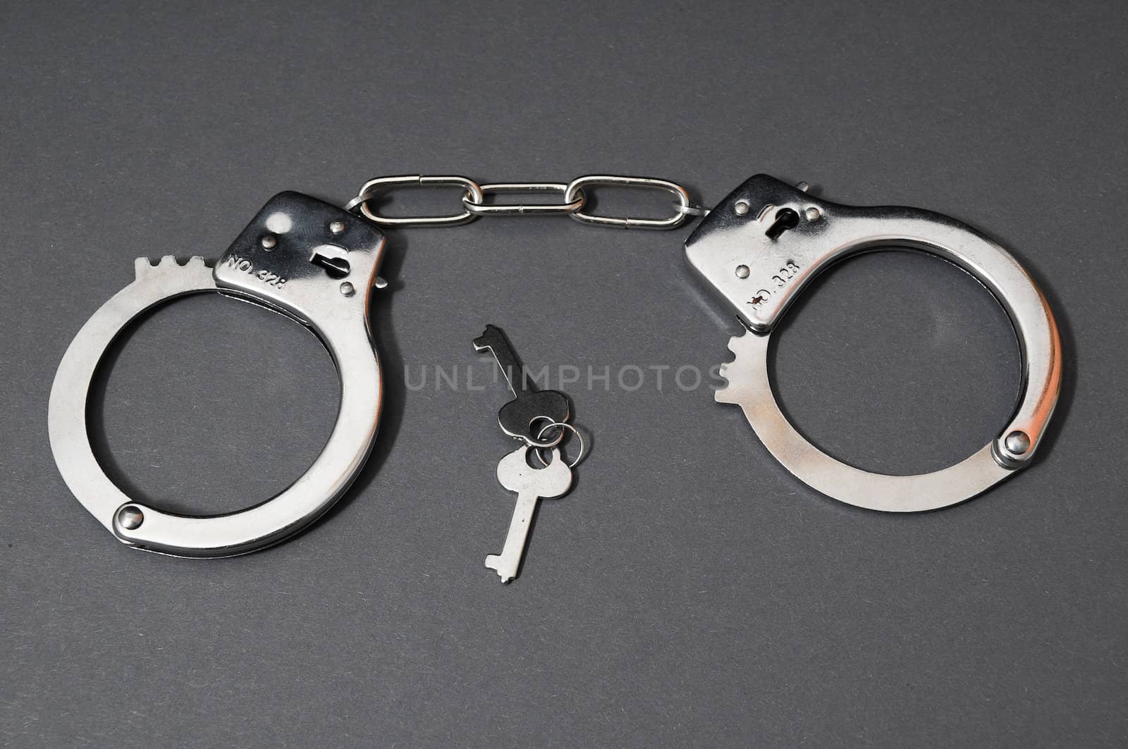 One Pair of Handcuffs on a Colored Background