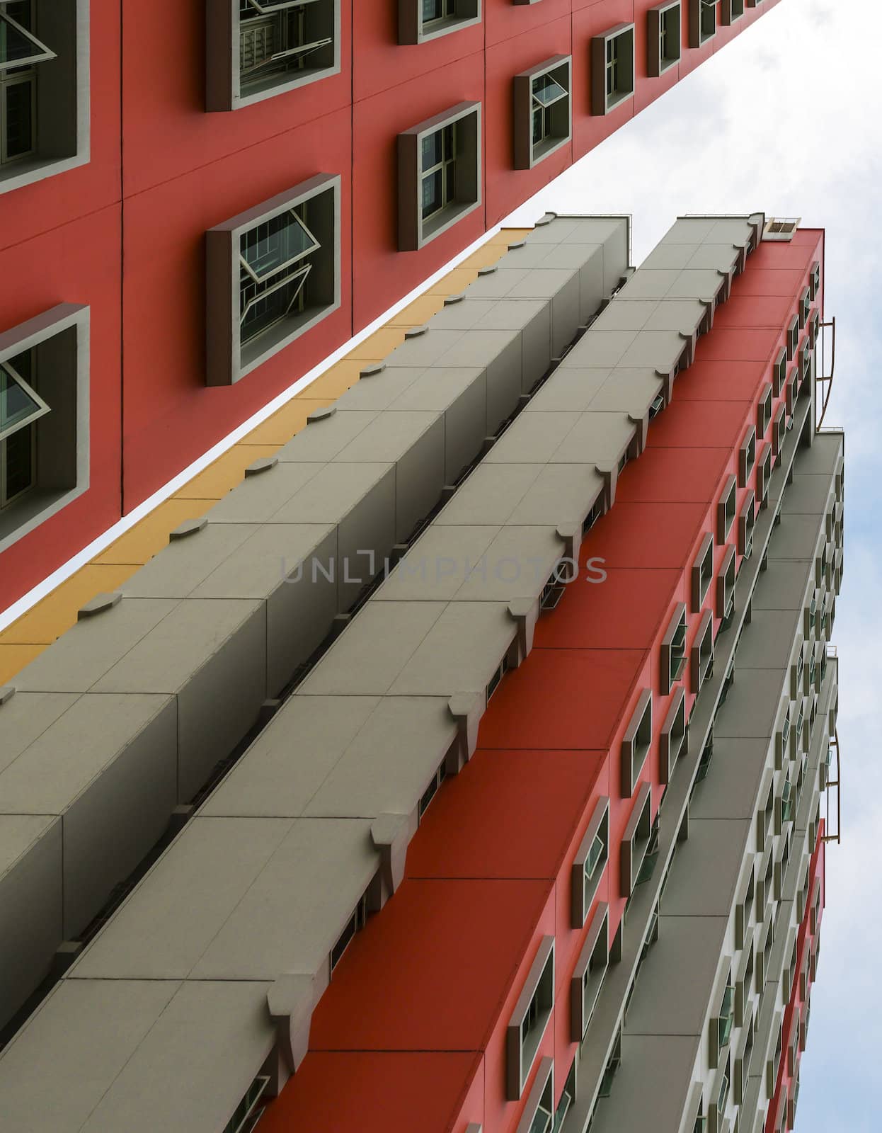 A low angle shot of a new colorful high rise apartment against the sky.
