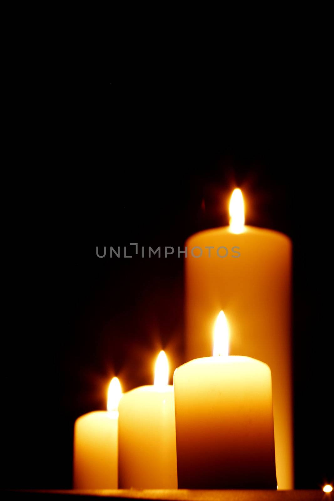 Closeup of burning candles on black background