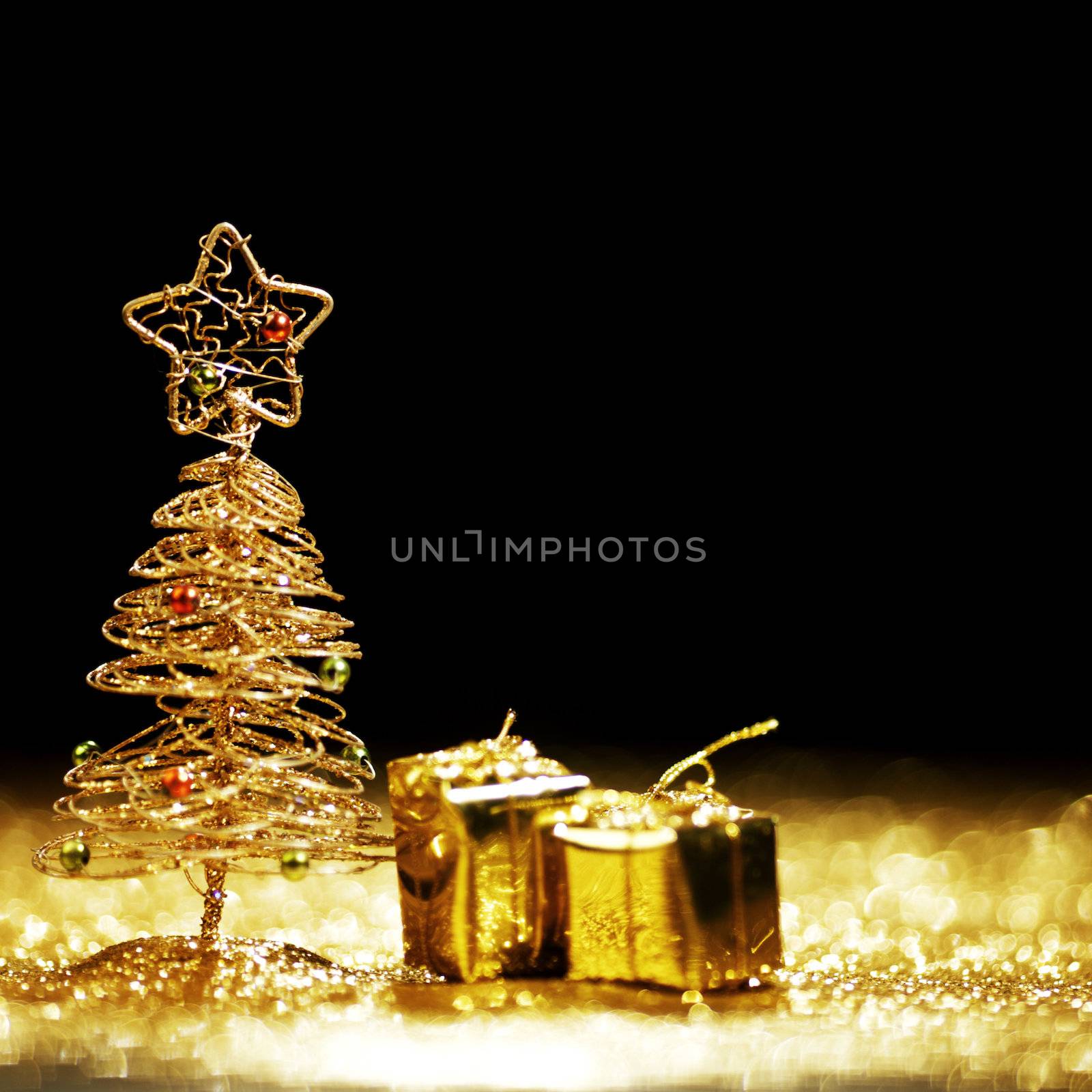 Golden christmas fir tree decoration and gifts on glitter background with black copy space