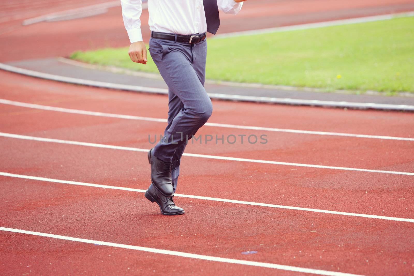 A businessman is running in the sports track