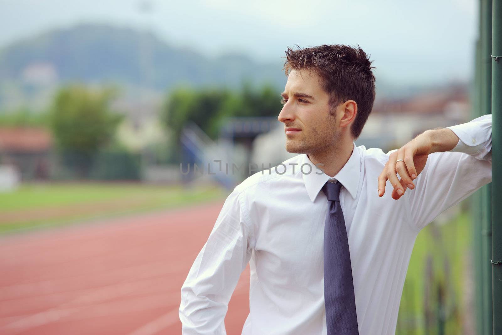 Portrait of young business man at sport field