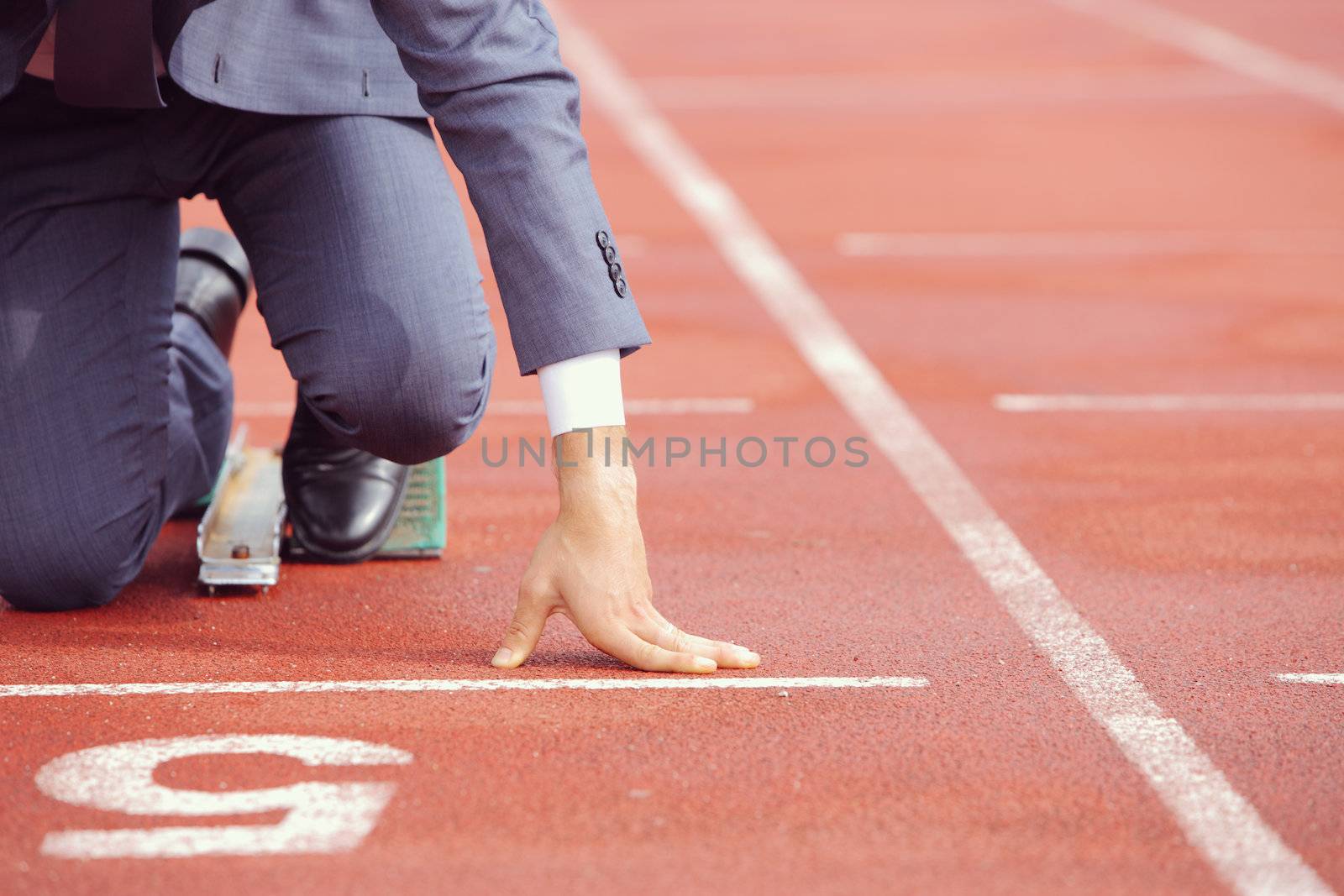 A businessman on a track ready to run 
