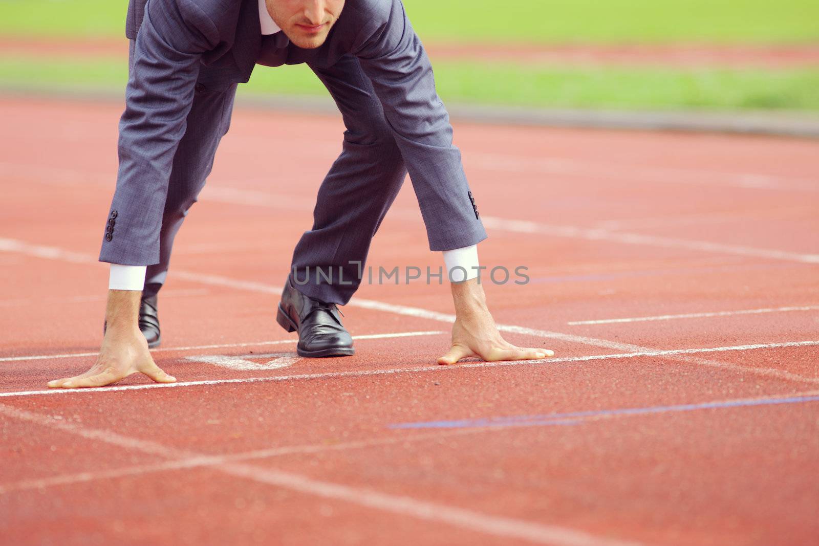 A businessman on a track ready to run 