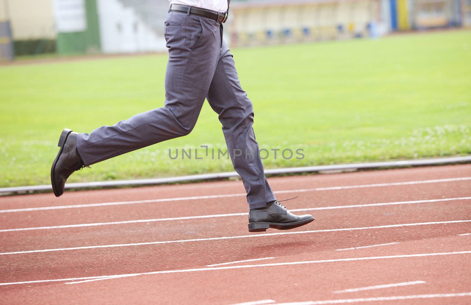 A businessman is running in the sports track