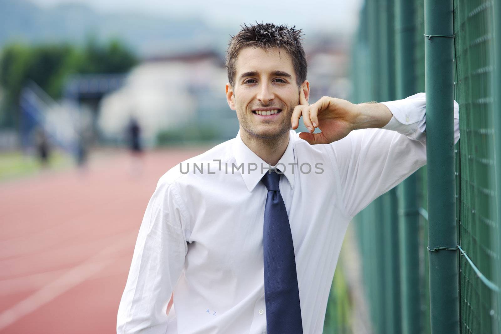 Portrait of young business man at sport field