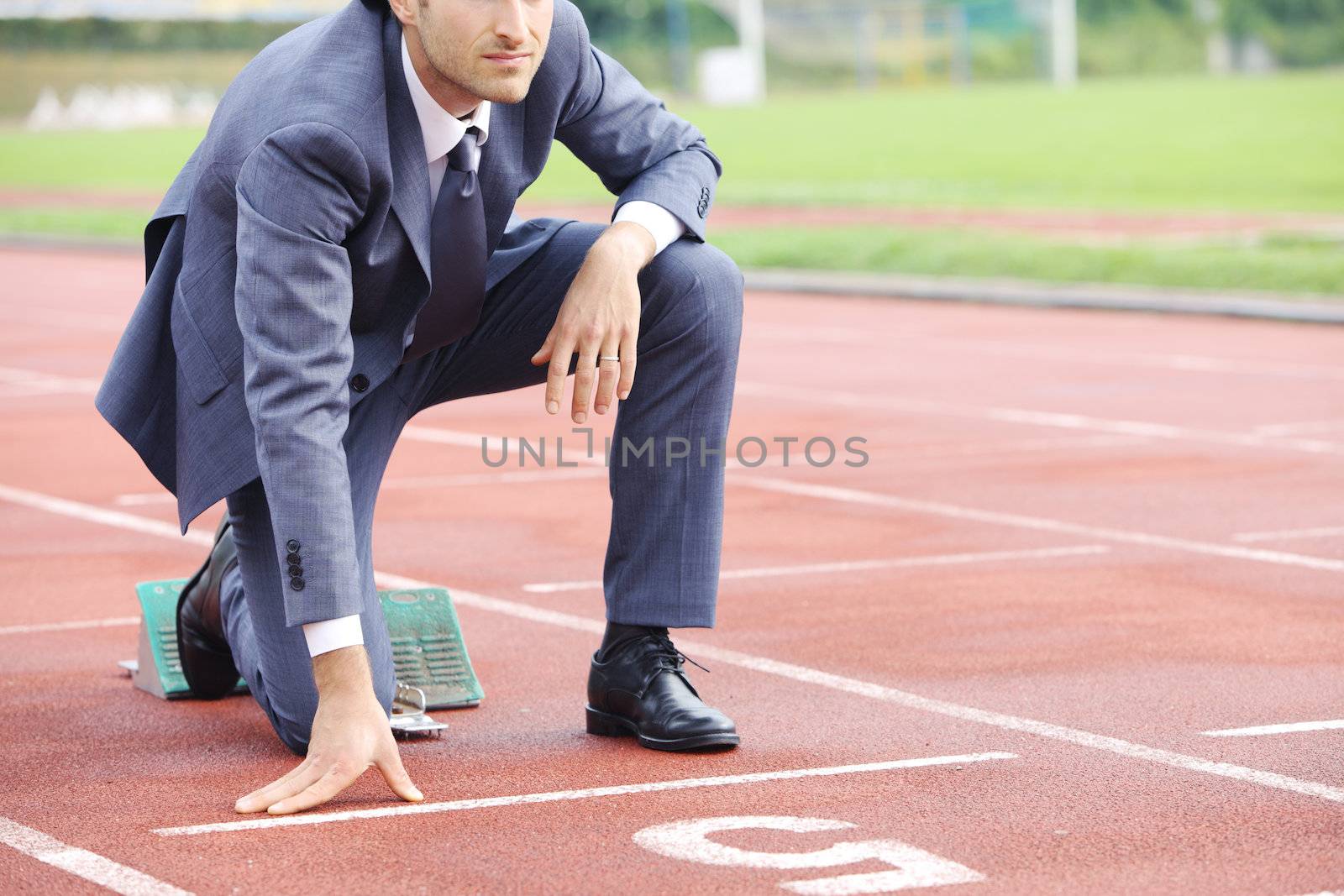 A businessman on a track ready to run 