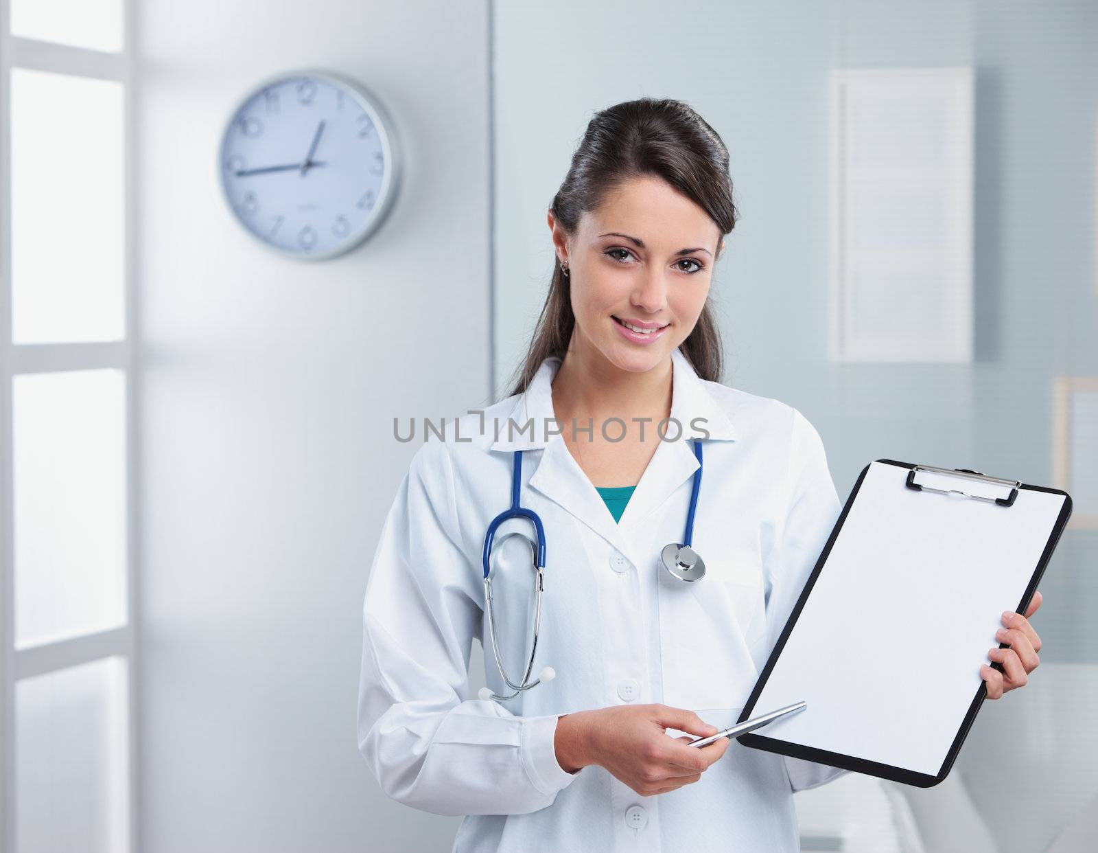Confident woman doctor pointing at the clipboard
