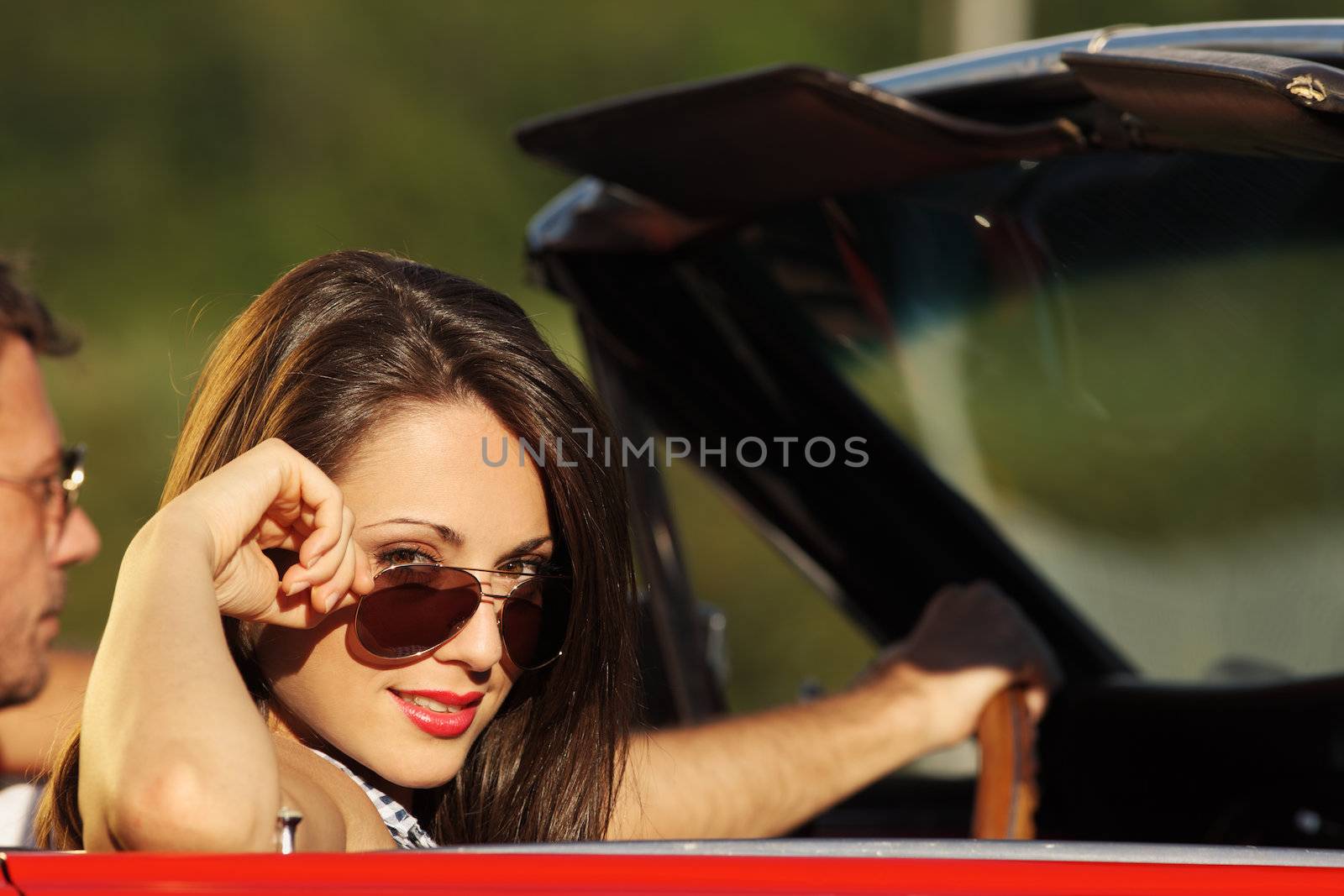 Portrait of a charming young woman in a convertible car