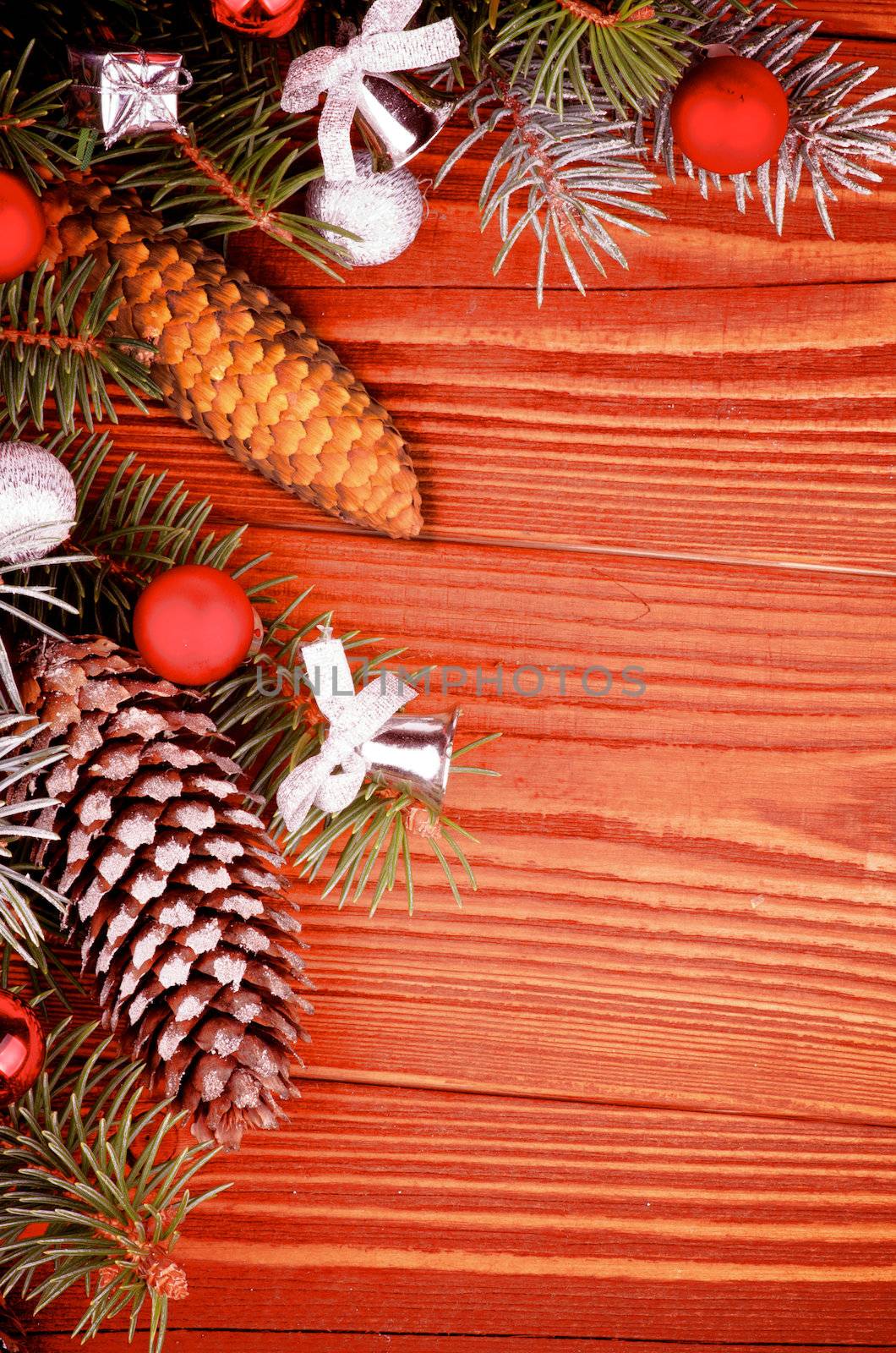 Arrangement of Spruce Branch and Fir Cones with Hoarfrost, Red and Silver Baubles, Bows closeup on Wooden background