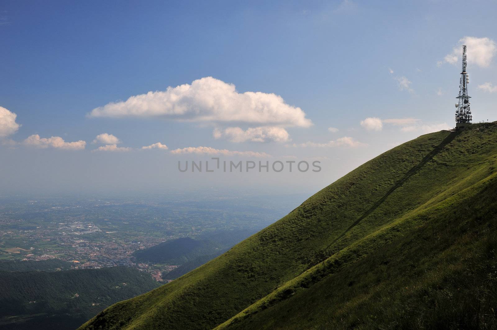 a television antenna watches over the valley from the top of a green hill, like a silent sentinel