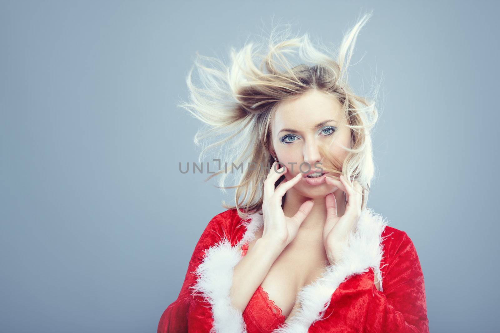 Beautiful lady in Santa costume on a studio background