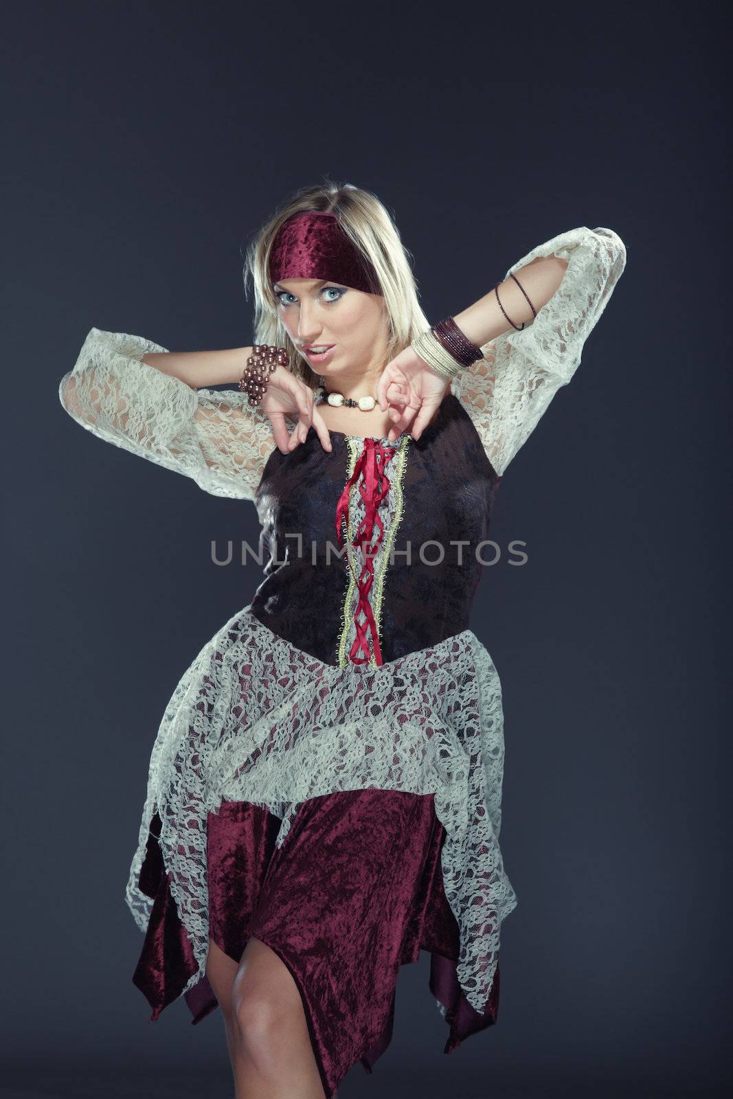 Lady in traditional costume performing national dance on a dark background