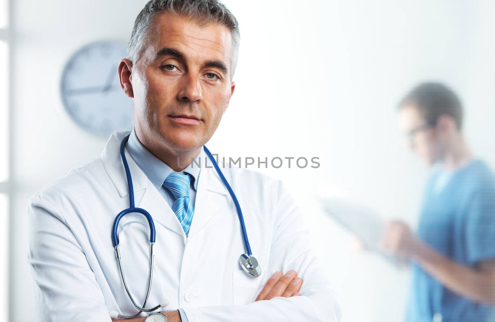 Portrait of a handsome male doctor, nurse on background