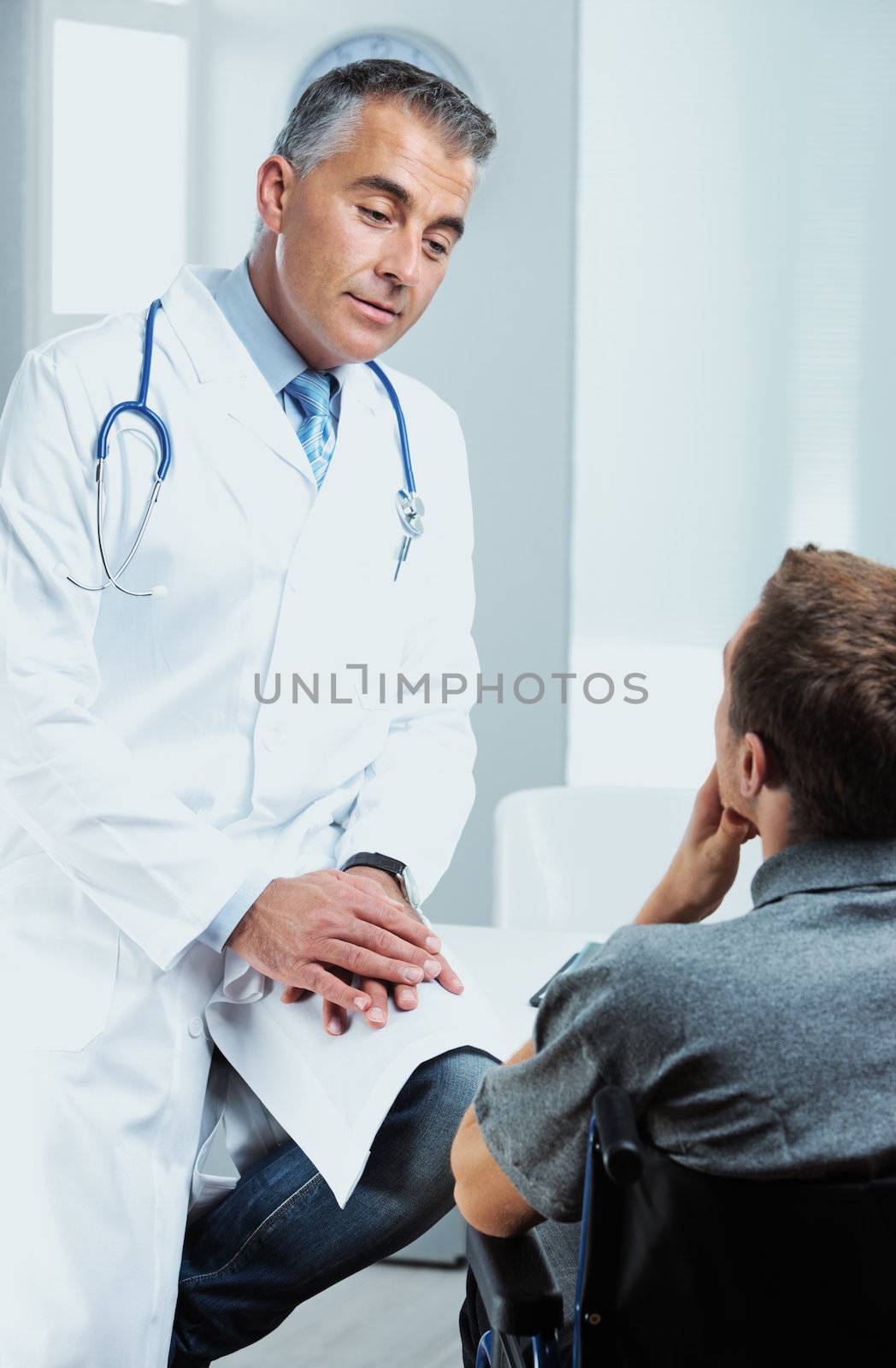 Portrait of a doctor talking to a young patient in a wheel chair