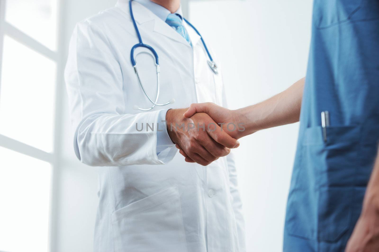 Two medical people handshaking at office 