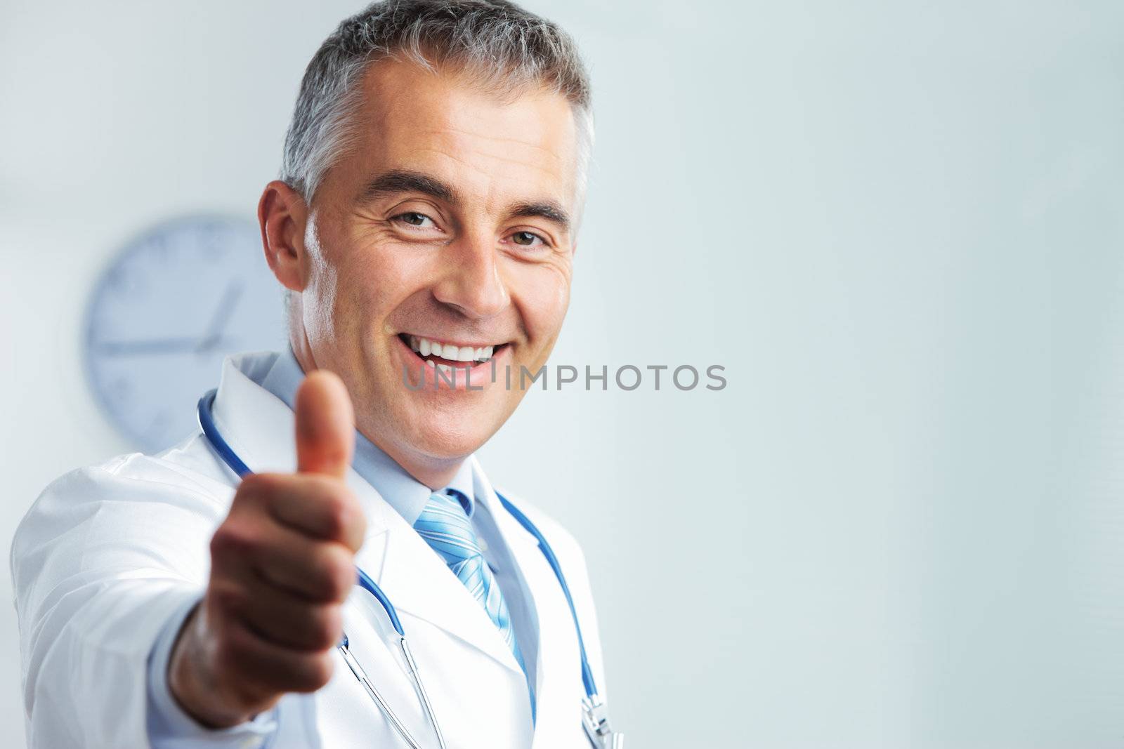 Portrait of middle-aged doctor showing you a thumbs up and smiling