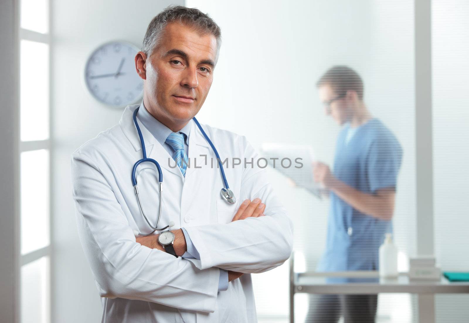 Portrait of a handsome male doctor, nurse on background