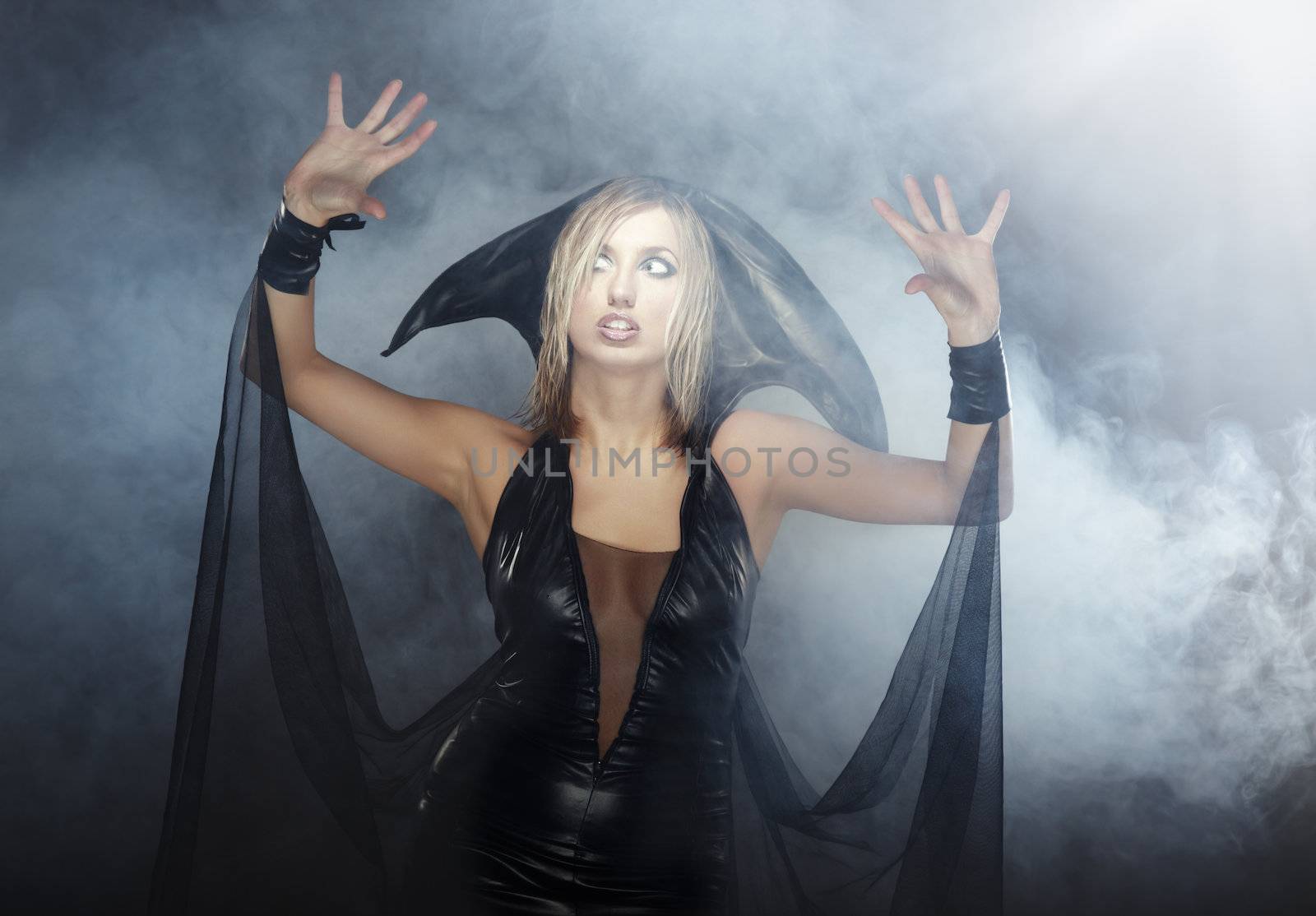 Indoors photo of the woman in witch costume in the heavy smoke