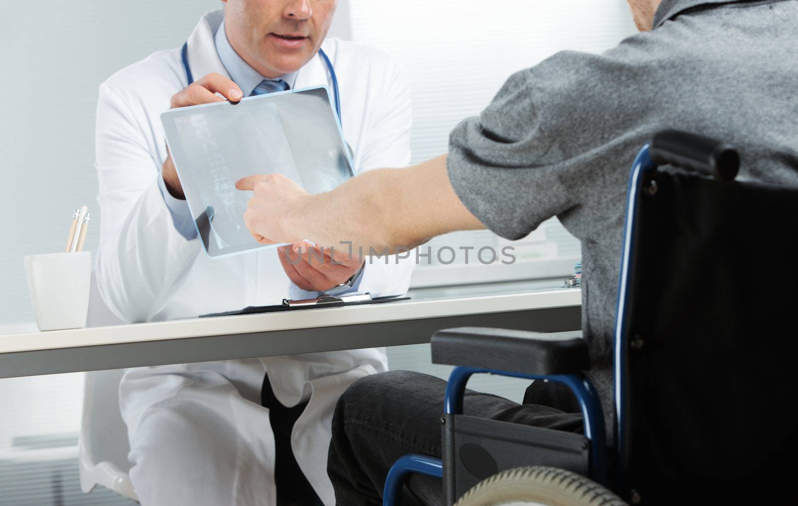 Doctor showing X-ray to patient by stokkete