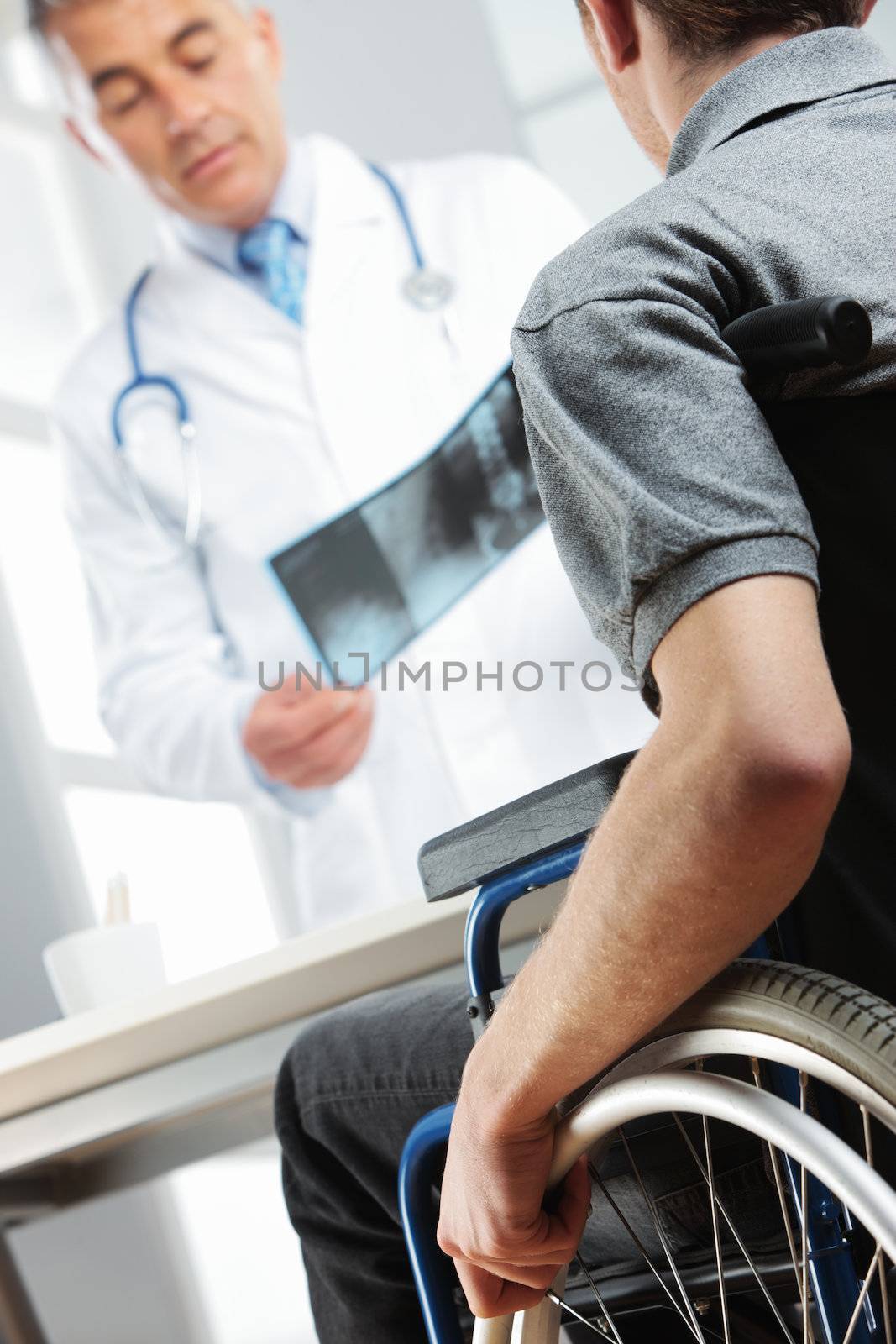 Disabled young man at doctor office by stokkete