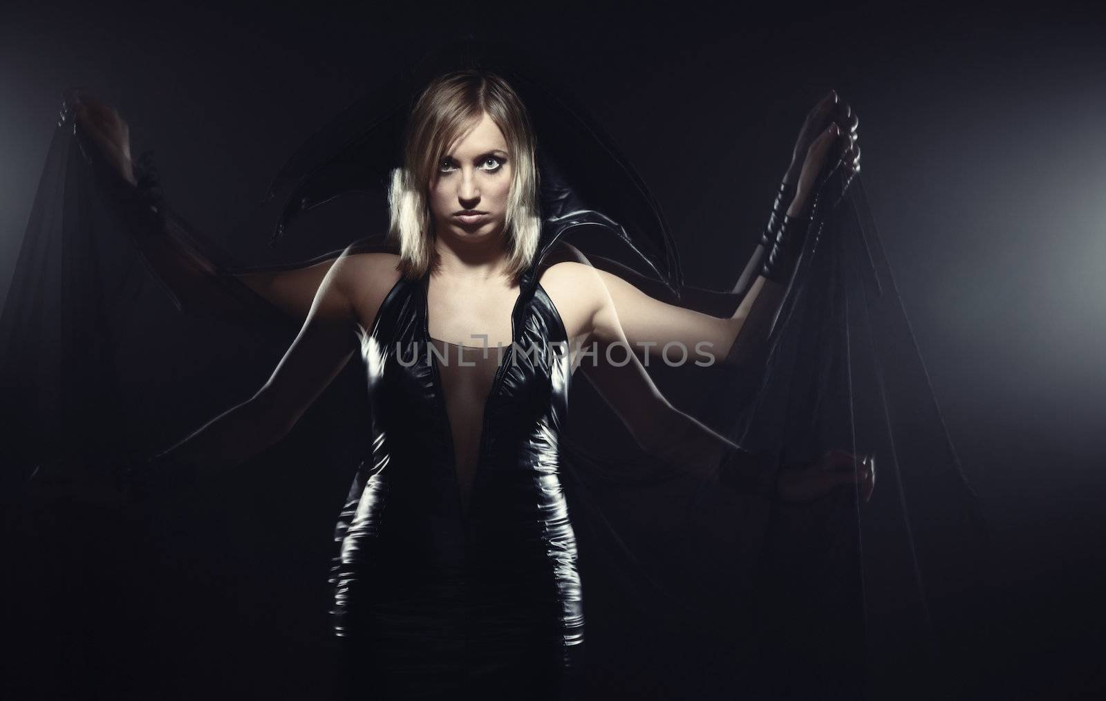 Woman in Halloween witch costume moving hands. Long exposure studio shot