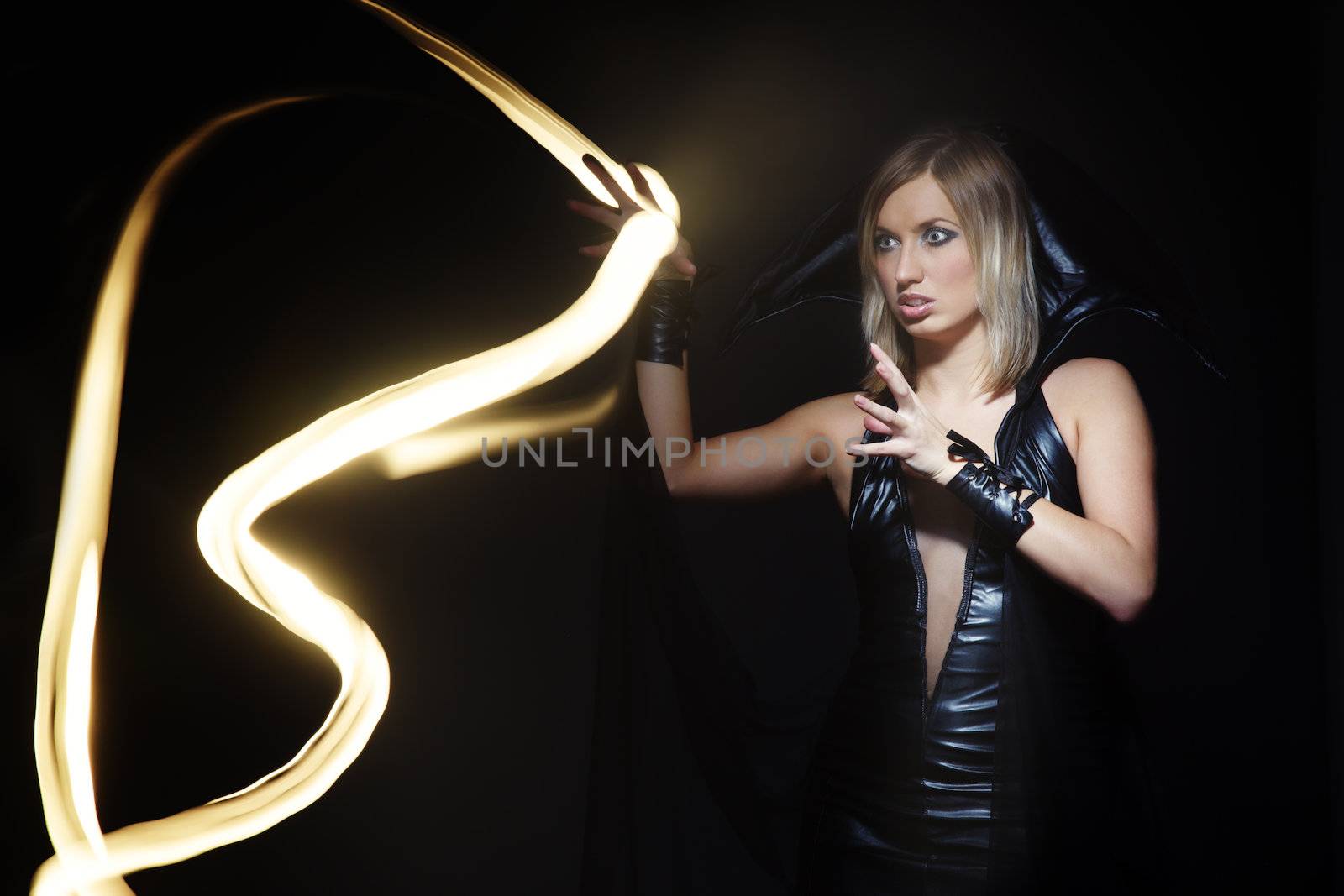 Magic light in studio and woman in witch costume. Long exposure