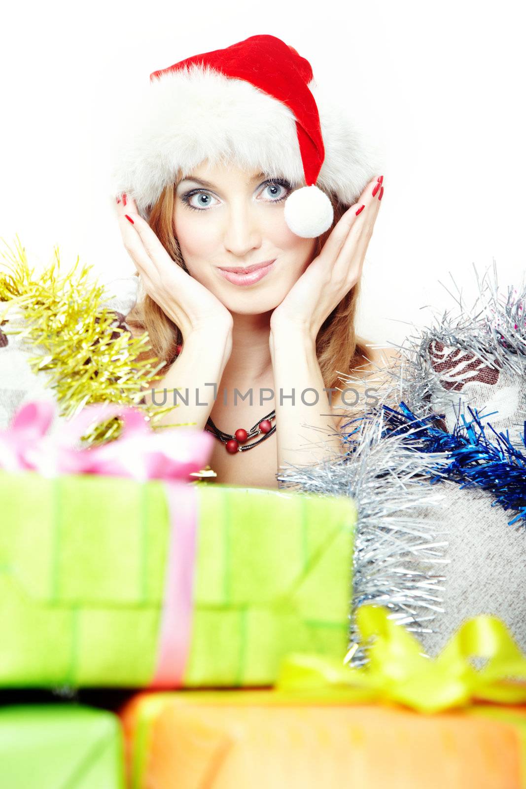 Headshot of the smiling lady in Santa Claus hat behind the boxes with Christmas gifts