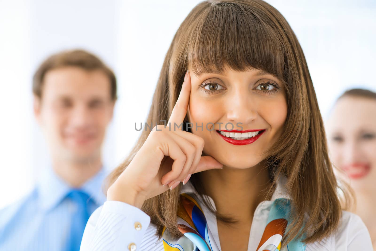 Portrait of a young successful business woman standing against colleagues