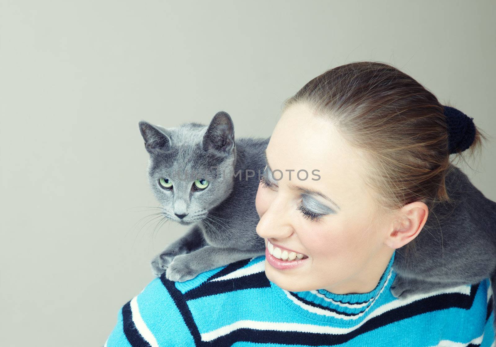 Smiling lady plays with cat indoors