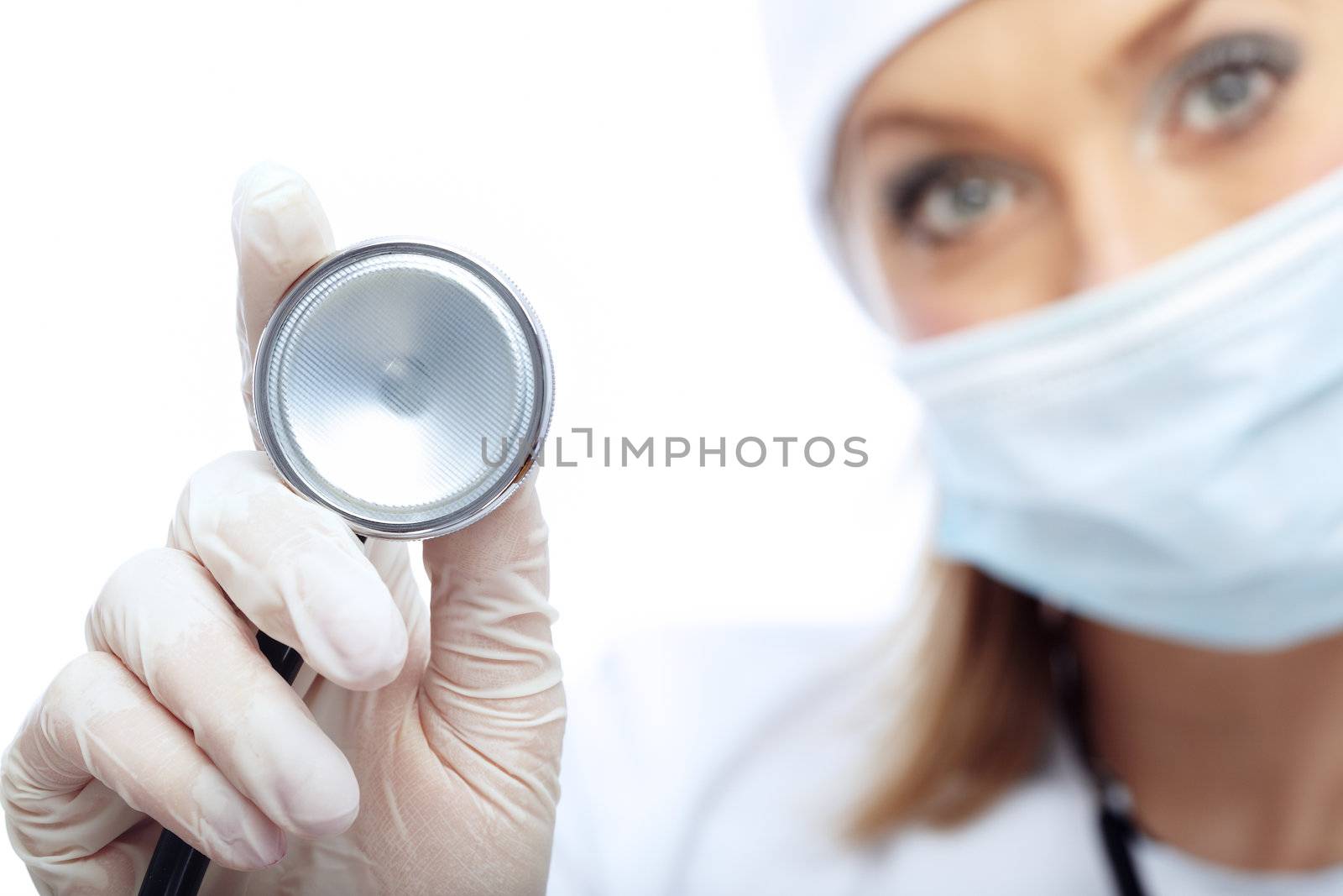 Close-up photo of the stethoscope and blurred docror in mask