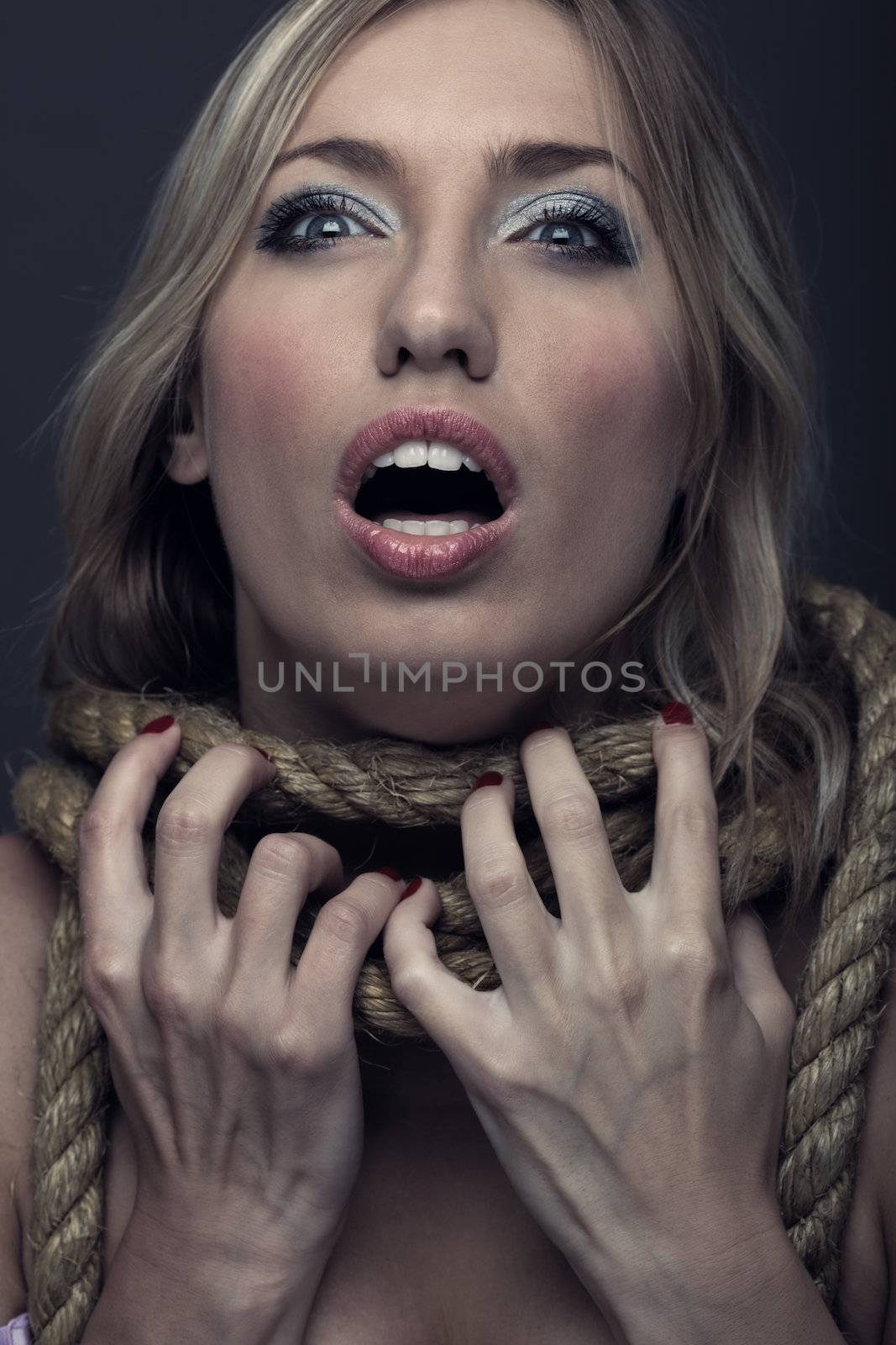 Female witch with rope on her neck. Studio portrait