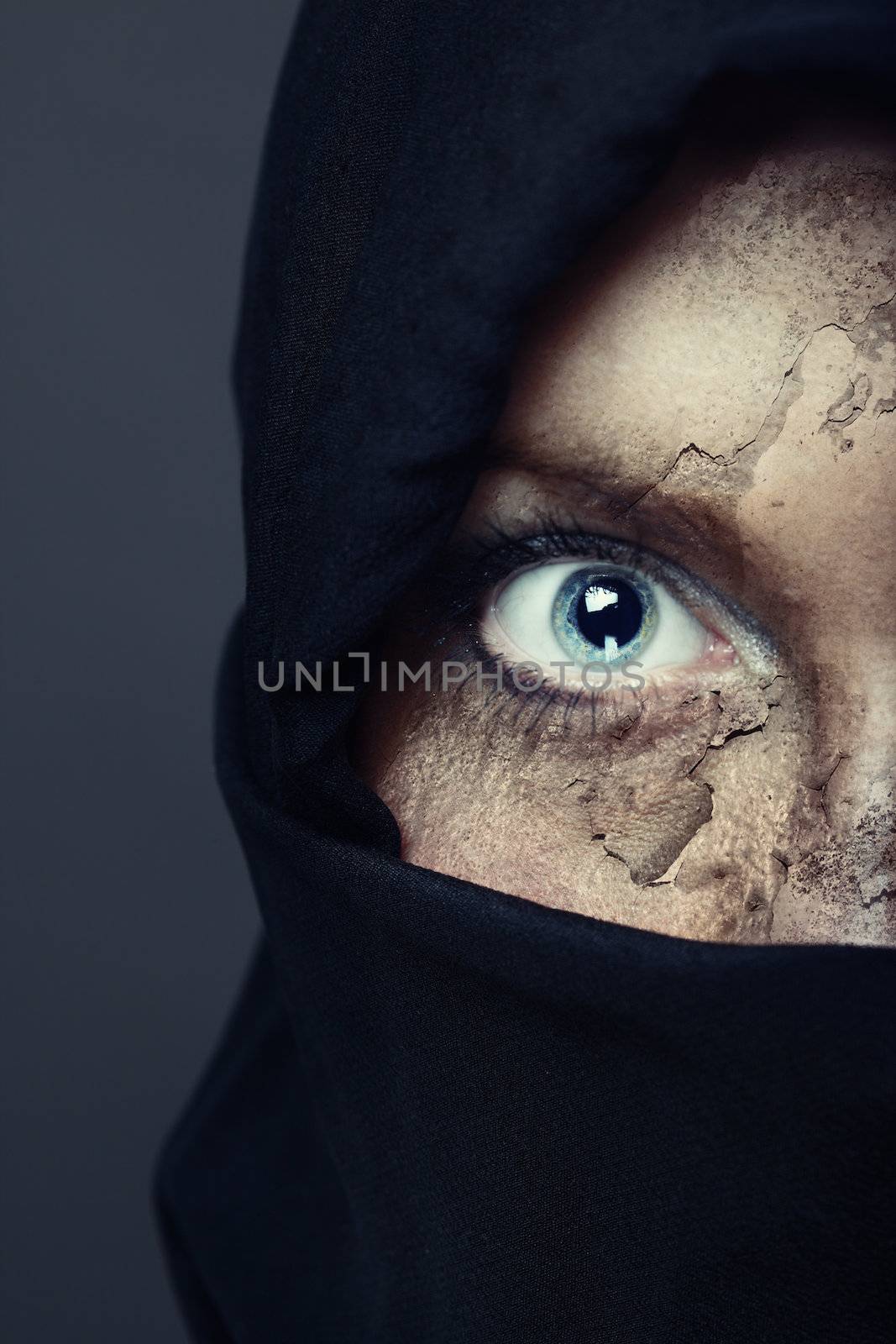 Half face of the human in black hood with damaged skin. Artistic colors and painting added