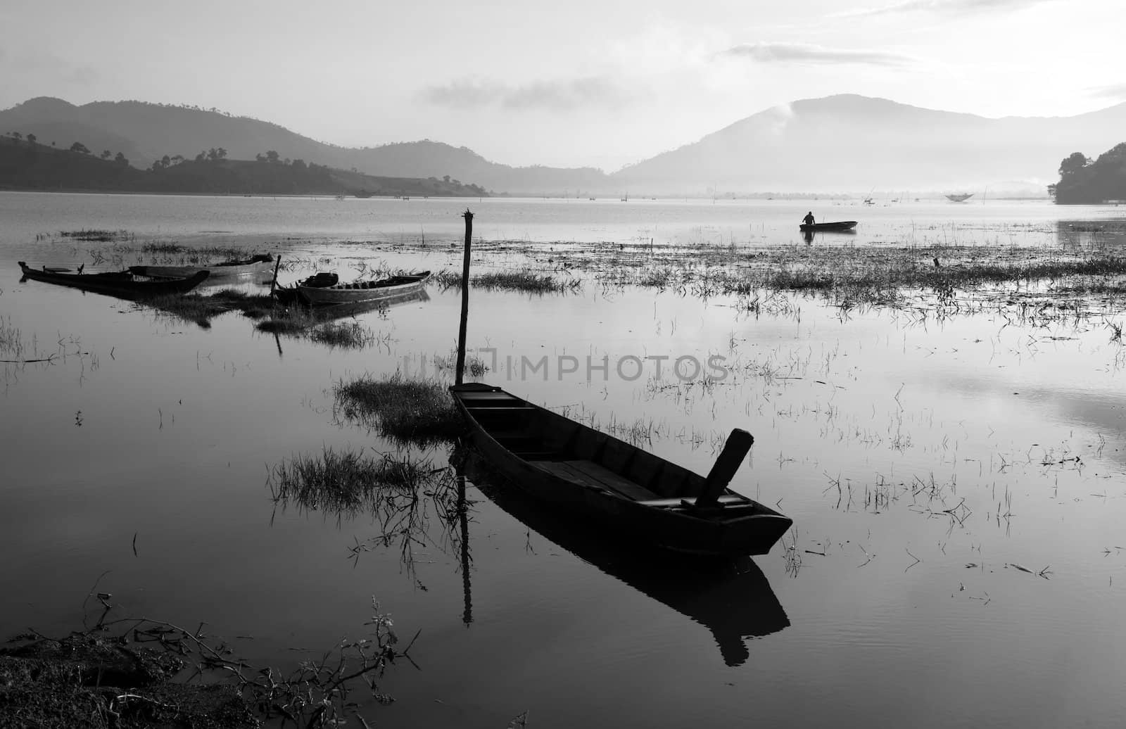 Fisherman row boat on quiet lake by xuanhuongho