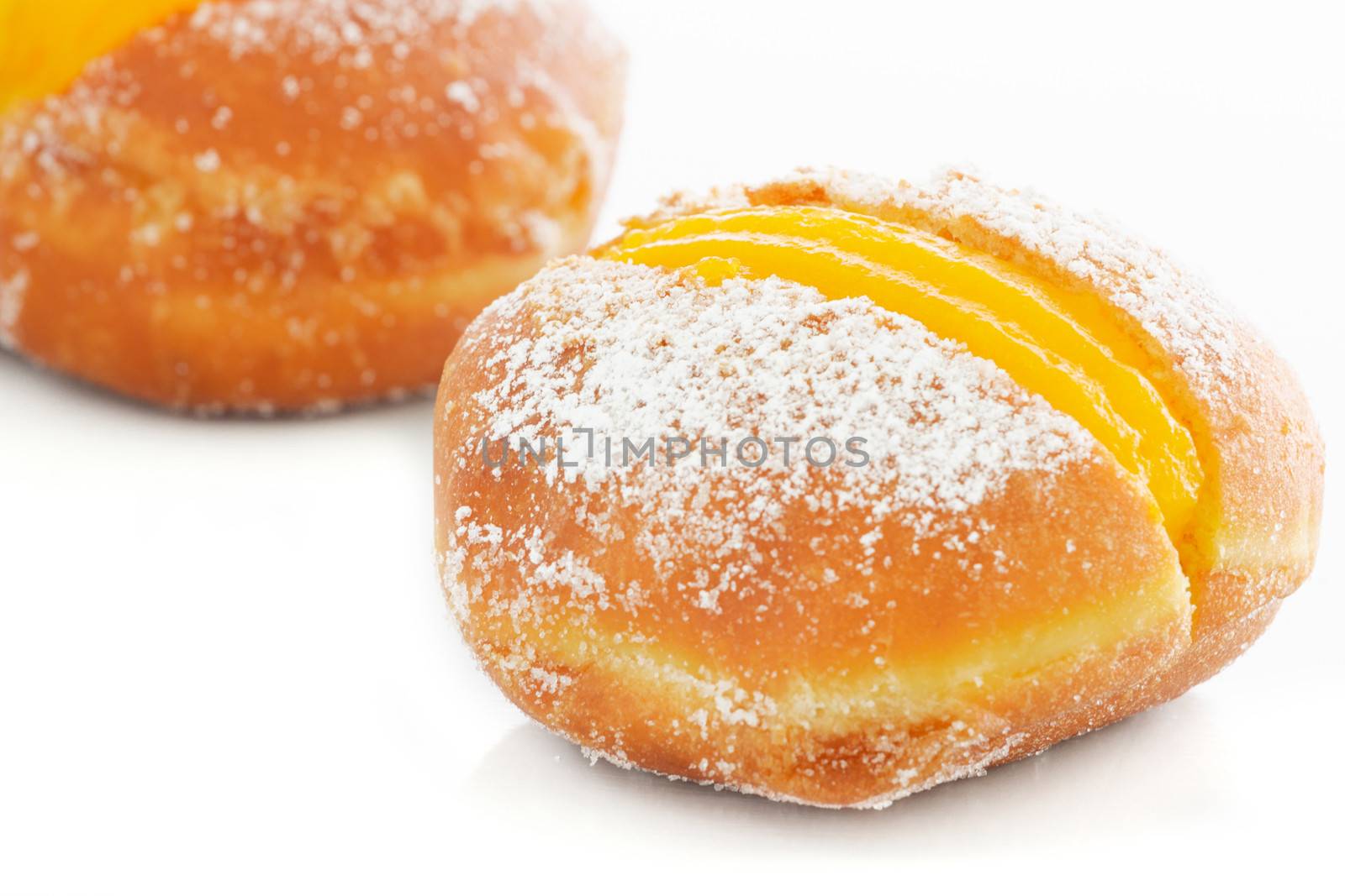 Portuguese doughnuts or Berliners with egg creme over white background