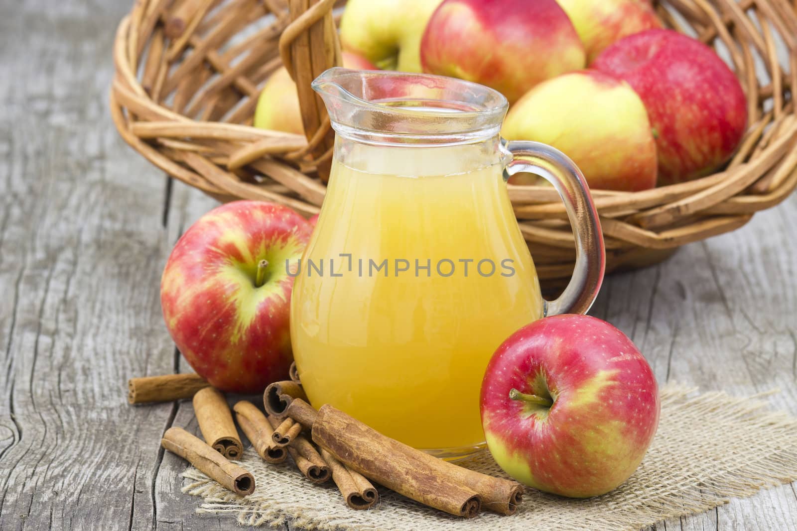 Apple juice and apples on wooden background