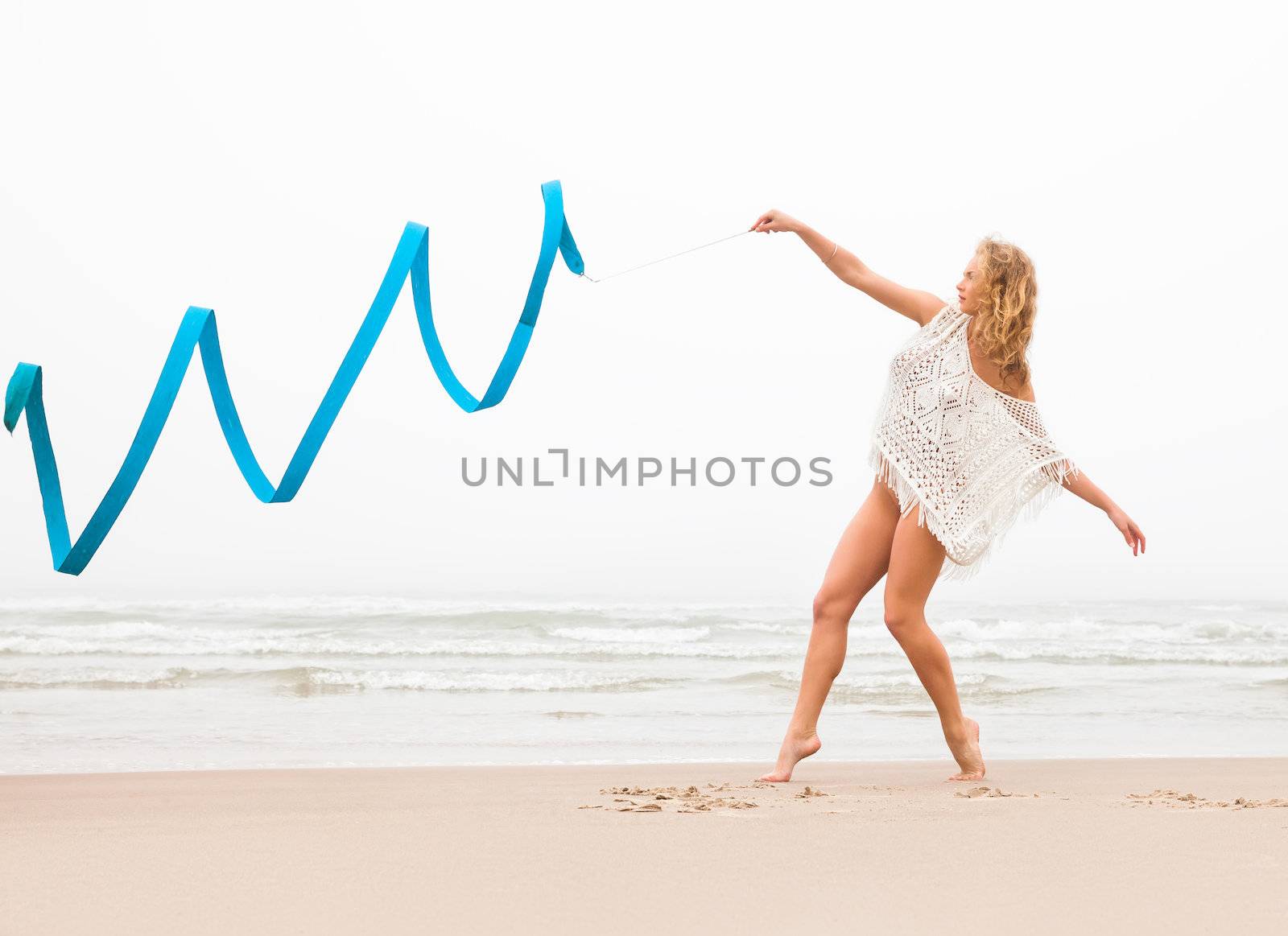 gymnast woman dance with ribbon on the beach by palinchak