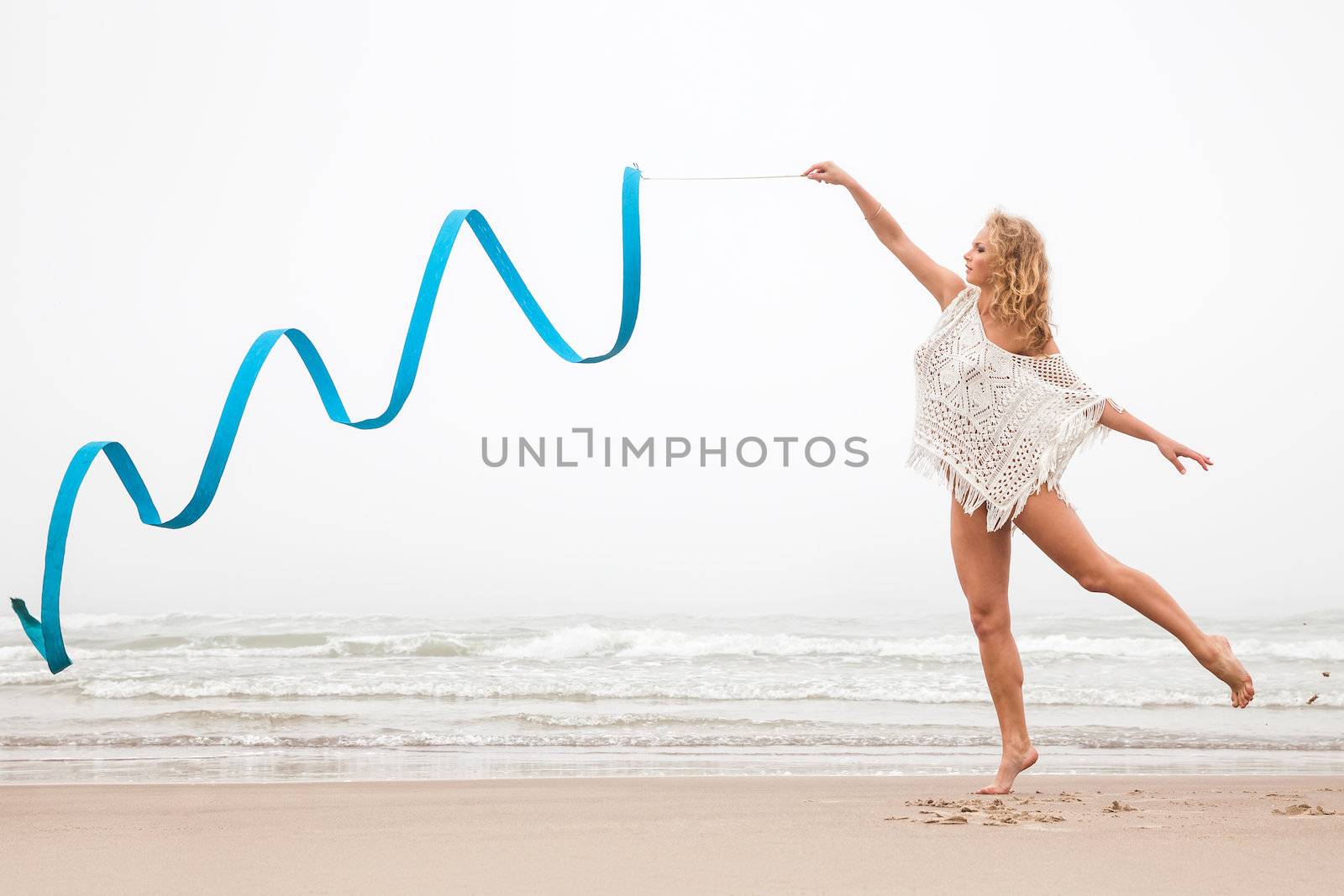 gymnast woman dance with ribbon on the beach by palinchak