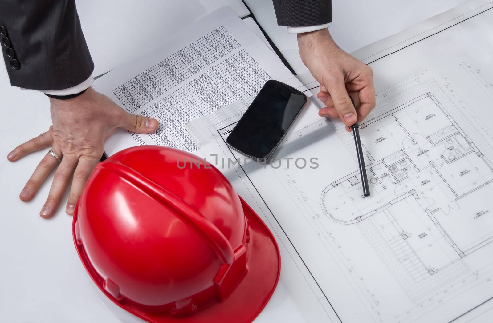Closeup of architect hands revising a house project plans