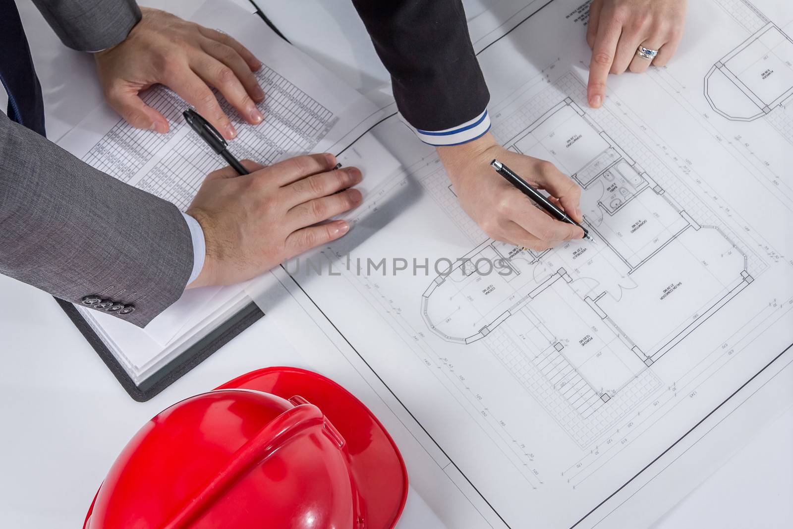 Closeup of architects hands revising a house project plans