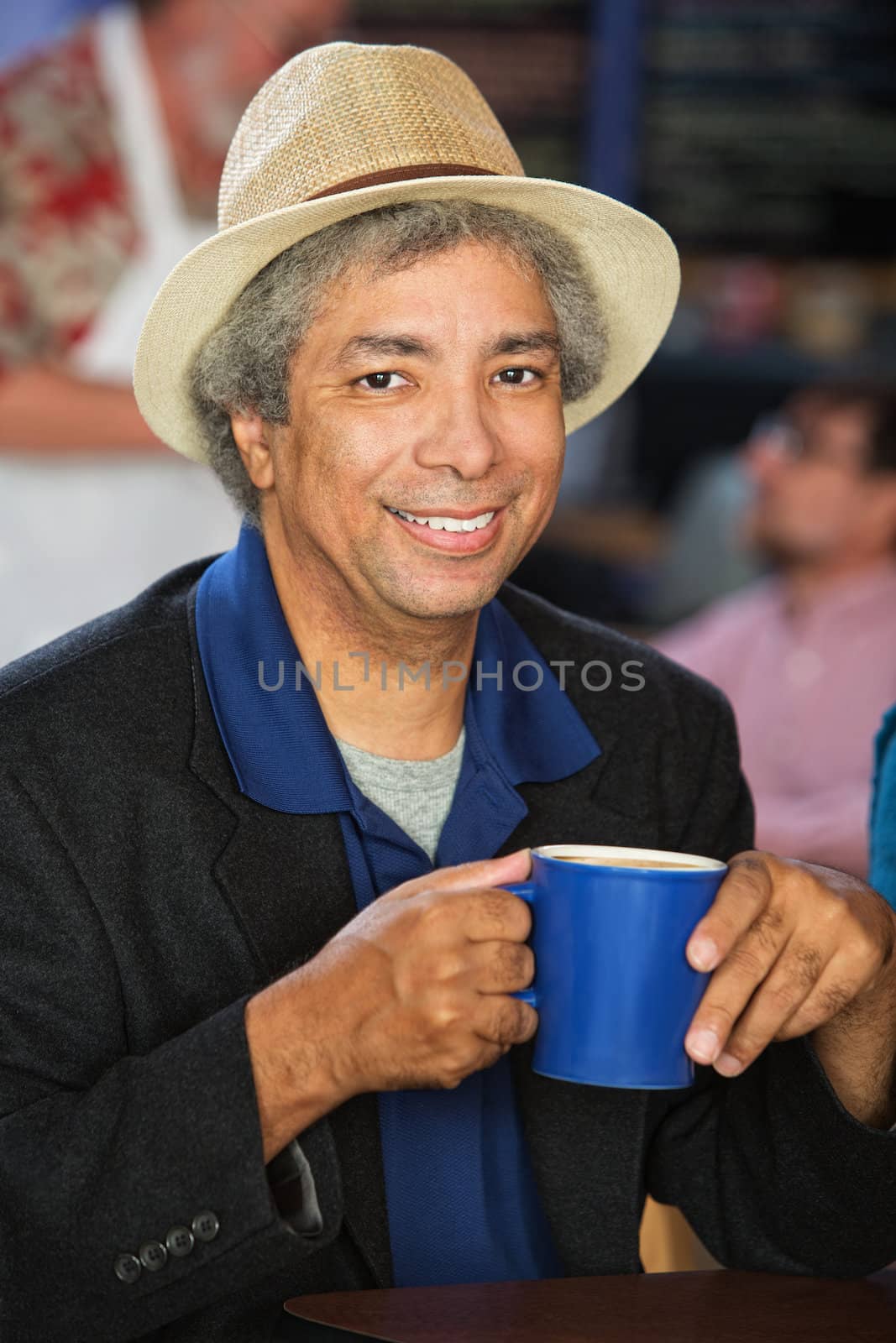 Smiling African man with hat and coffee cup